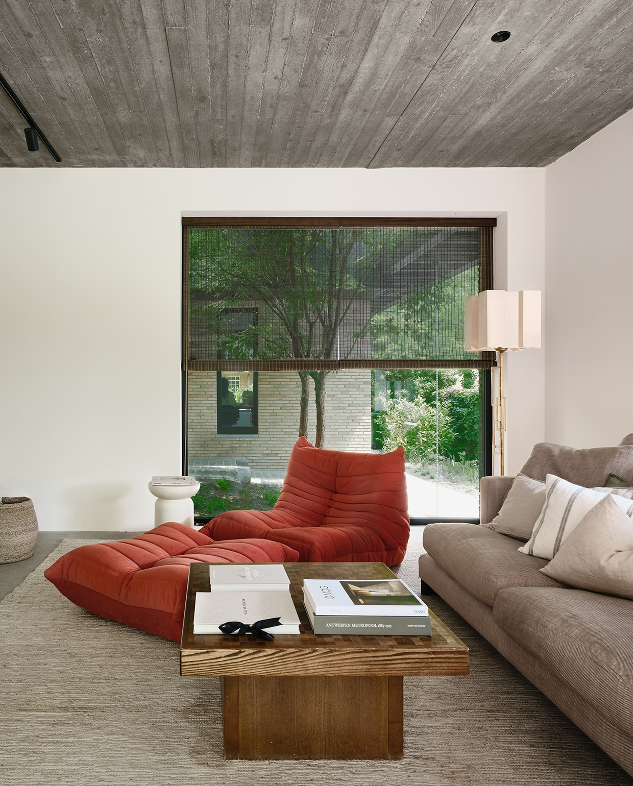 Door de verhoogde ligging krijgt de tv-hoek een intieme sfeer. Fauteuil Ligne Roset, turquoise lamp Paulette in ’t Stad, hennep tapijt Loook. De vertrouwde sofa en salontafel uit het vorige appartement van het gezin maken het geheel compleet. stijlvol wonen 2-2025 | fotografie Mr Frank | tekst Maya Toebat