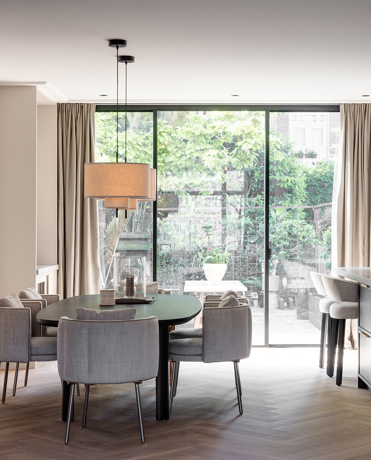 Céline van Haaren nam de stoffen lampenkappen boven de eettafel mee uit een boetiek in Engeland. Eettafel Dan, ontworpen door Christophe Delcourt, en stoelen Torii, een ontwerp van Nendo, van Minotti. Gordijnen Frankly Amsterdam. stijlvol wonen 2-2025 | Fotografie Jurrit van der Waal | Tekst Yvonne van Galen