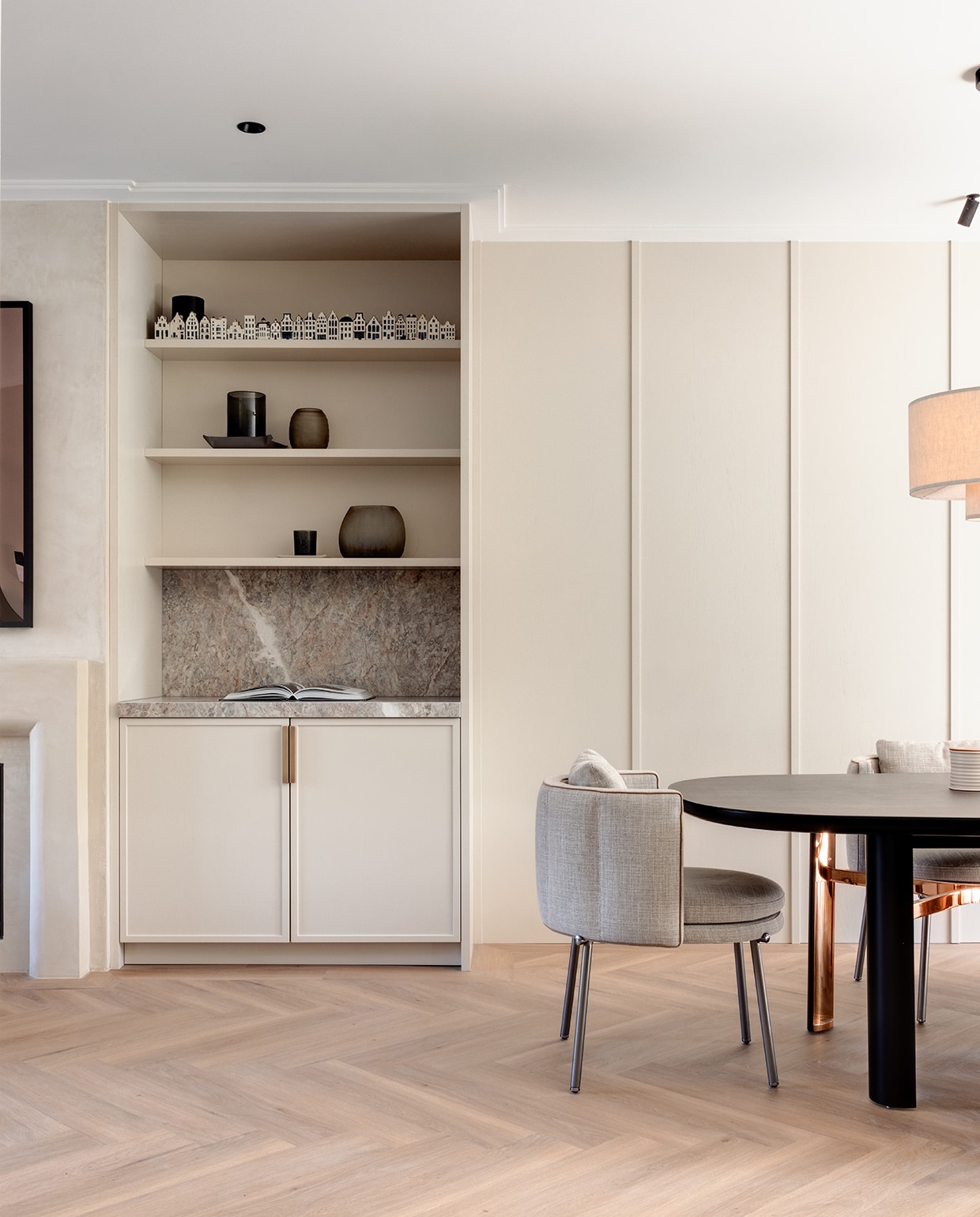 Het wandmeubel kreeg dezelfde kleur als de keuken, Rolling Fog van Little Greene. Ook hier een nis in marmer, om te benadrukken dat de eetkeuken als een geheel functioneert. In de kast vazen van Guaxs en porseleinen KLM ‘verzamelhuisjes’. stijlvol wonen 2-2025 | Fotografie Jurrit van der Waal | Tekst Yvonne van Galen