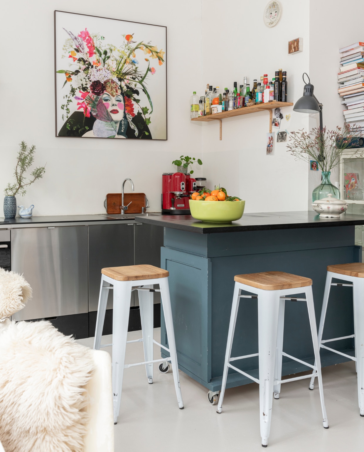 Roestvrijstalen keuken en afzuigkap Marktplaats, lades eronder zelfgemaakt. Bar zelfgemaakt van oude ladekasten van de kringloopwinkel. Barkrukken van Tolix van Marktplaats. De bank is bekleed met stof van Alaloes Object &amp; Interieur. Schapenvachten, theepot Bredemeijer. Zwarte wandlamp Ikea. Kunst aan de muur gemaakt door Noor. Vaas op bar, kandelaars en vogel op tafel Vossenplein Brussel. Oude schaal met deksel en snijplanken van oma. Overig onbekend. vtwonen special binnenkijken 12-2021 | styling Sharon Roest | fotografie Caroline Martinot