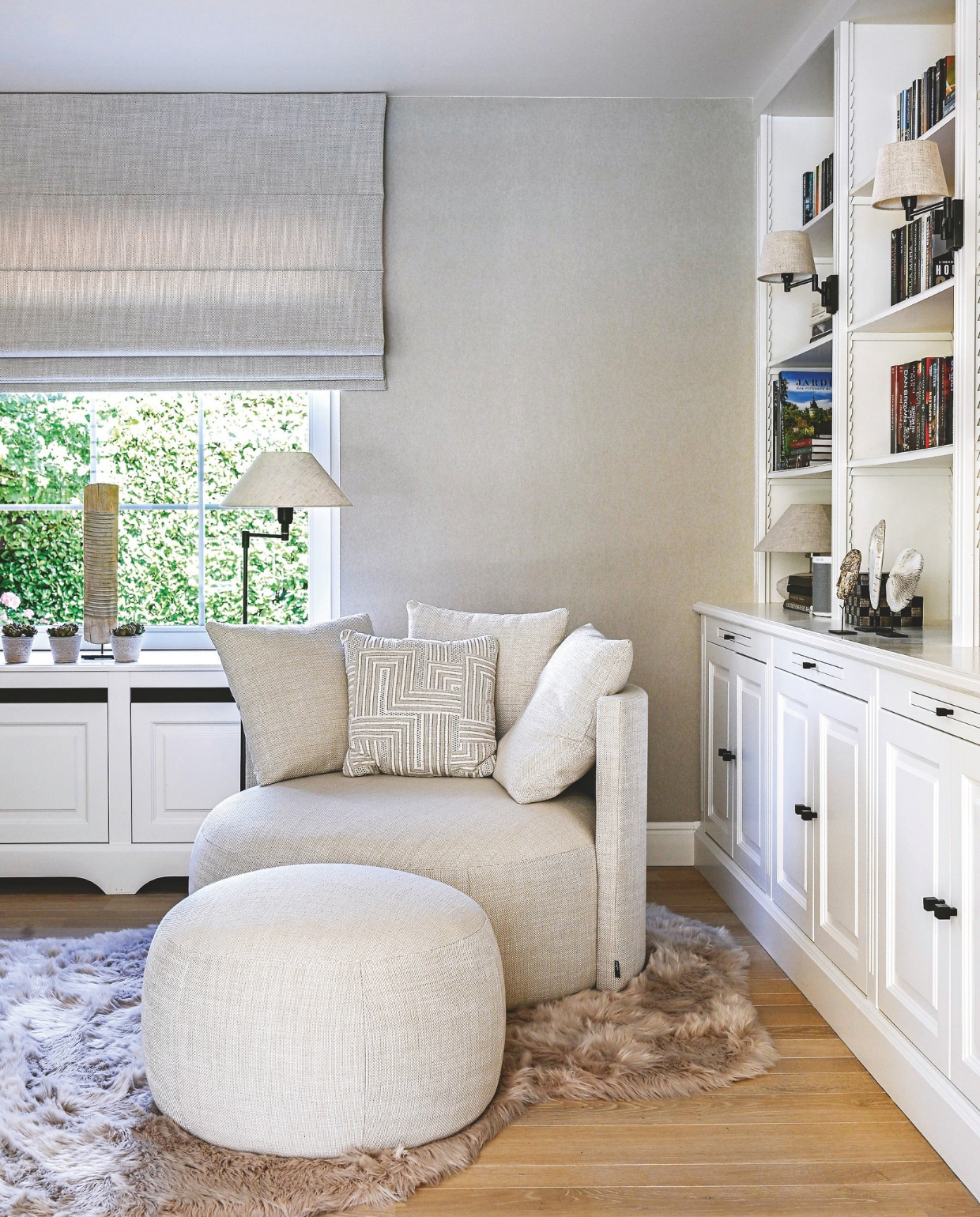 Fauteuil met poef en kussens Pastille Lounge Swing van Passe Partout. Bekleding fauteuil en stof gordijn Indera. Sierkussen Prananatha. Vloerkleed  Tiseco. Bibliotheekkast aangepast door meubelmaker Klaas van Interno Interieur. Vergelijkbare lampenlampenlicht.nl. vtwonen Landelijk 2-2025 | Fotografie Claude Smekens | Tekst Yvonne van Galen