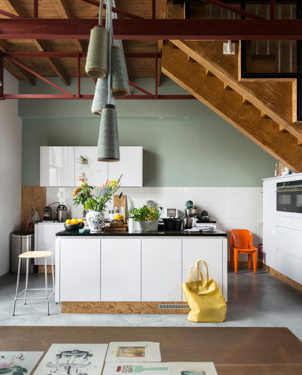 Keuken uit een showroom met brandschade. ‘Er zit zelfs een afzuigelement met lift in.’ Vaas van CTRLZAK, kruidenbak van Royal VKB, houten snijplank van Graphic Playground, pannen van BK, herkomst kruk en oranje stoel onbekend. vtwonen 06-2018 | fotografie Stan Koolen | styling Emmy van Dantzig, Mijke Niks