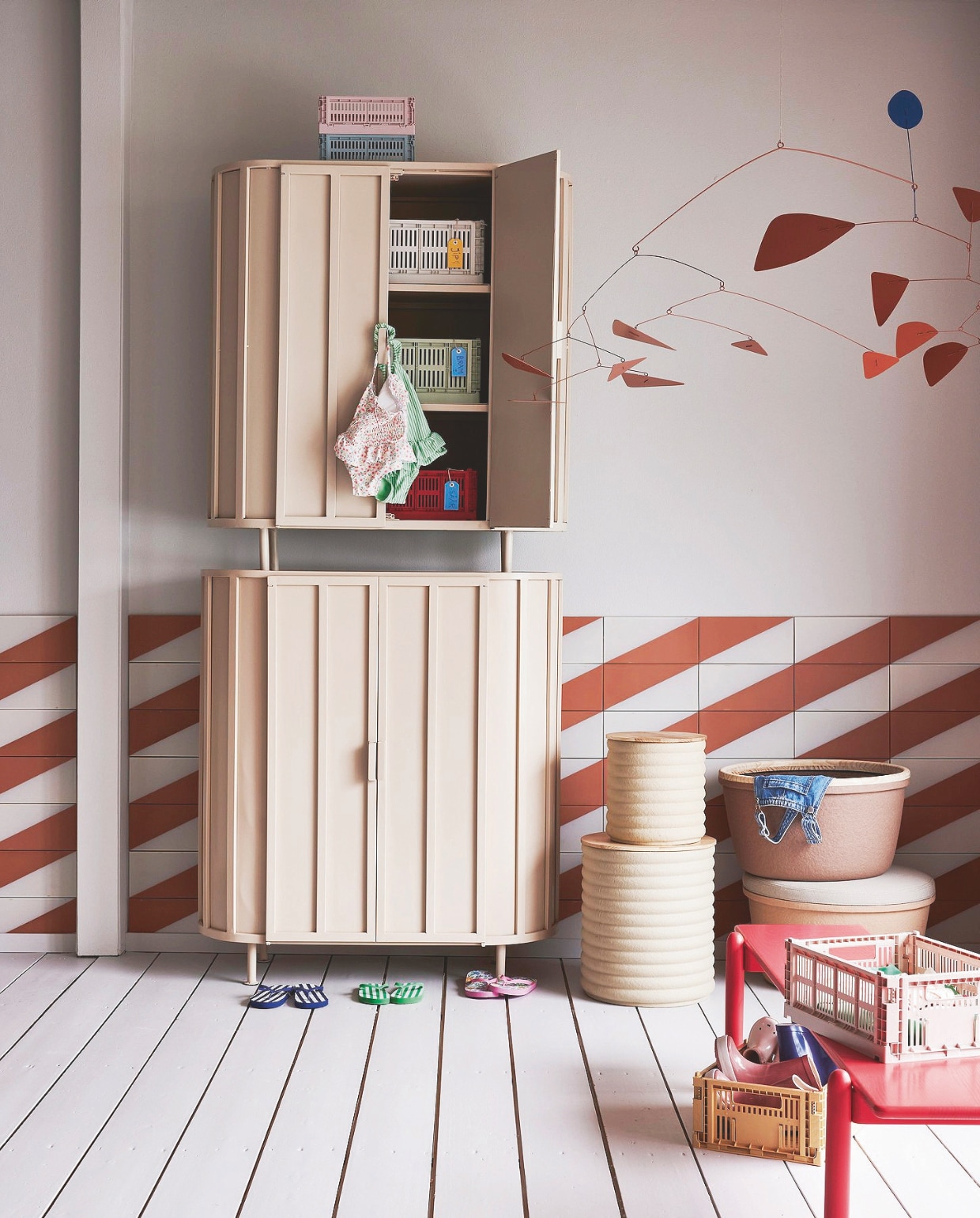 Tegels met diagonale streep, prijs op aanvraag, houten bank Lyts van SlowWood, 150x30x35 cm (bxdxh) € 995,-, mobile Zaniah van Solito Mobiles € 550,- (studioslow.nl). Metalen kasten Aspen van New Routz, 100x42x114 cm (bxdxh) € 1195,- (hetkabinet.nl). Kunststof kratten Colour Crate vanaf € 6,- (hay.nl). Bijzettafels met opbergruimte Caterpillar, gerecycled papier en fsc-gecertificeerd hout, set van 2 € 289,-, opbergmanden Barcelona, gerecycled papier en fsc-gecertificeerd hout, per stuk € 129,- (paperpasteliving.com). Kartonnen naamlabels € 1,50, rubberen regenlaarzen € 19,-, teenslippers vanaf € 7,-, kleding (hema.nl). vtwonen 08-2024 | styling Marianne Luning | fotografie Alexander van Berge