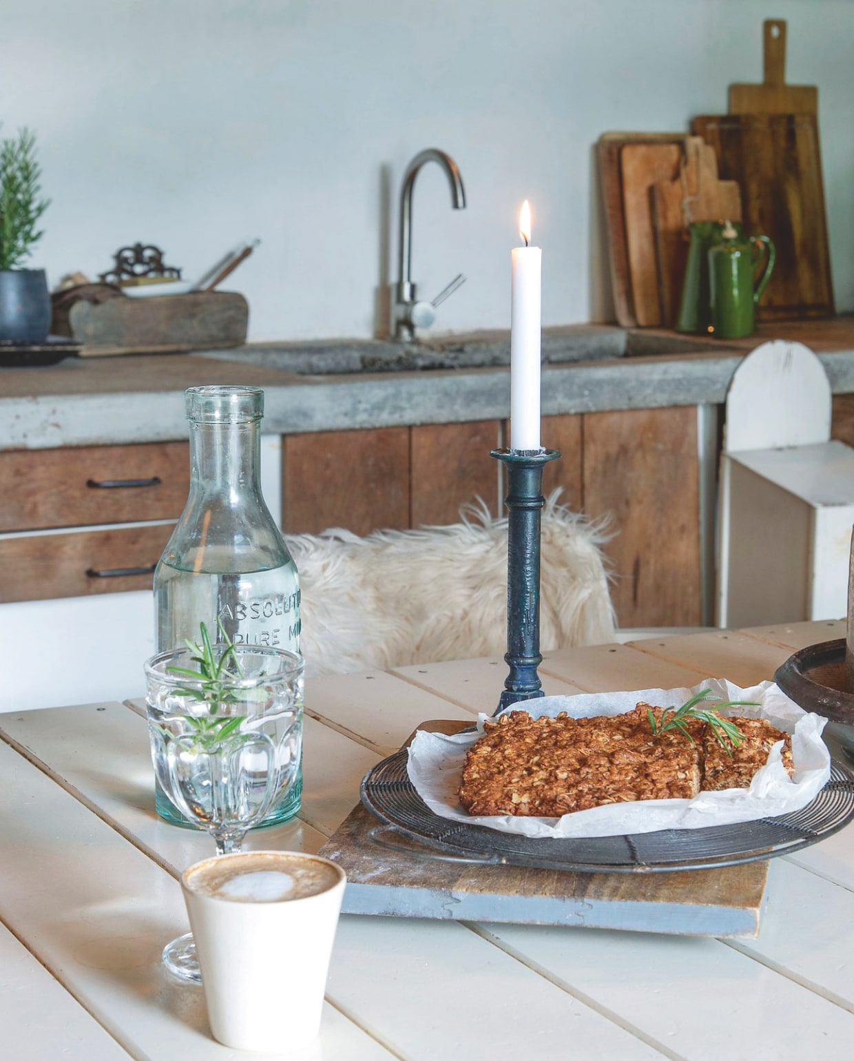 Het vaste betonnen aanrecht met ingegoten gootsteen heeft simpele kastdeuren en laden van hout, wat de robuuste, rustieke stijl van de keuken onderstreept. vtwonen Landelijk 2-2025 | styling Peet Styling! | fotografie Joyce Vloet | tekst Marie Masureel