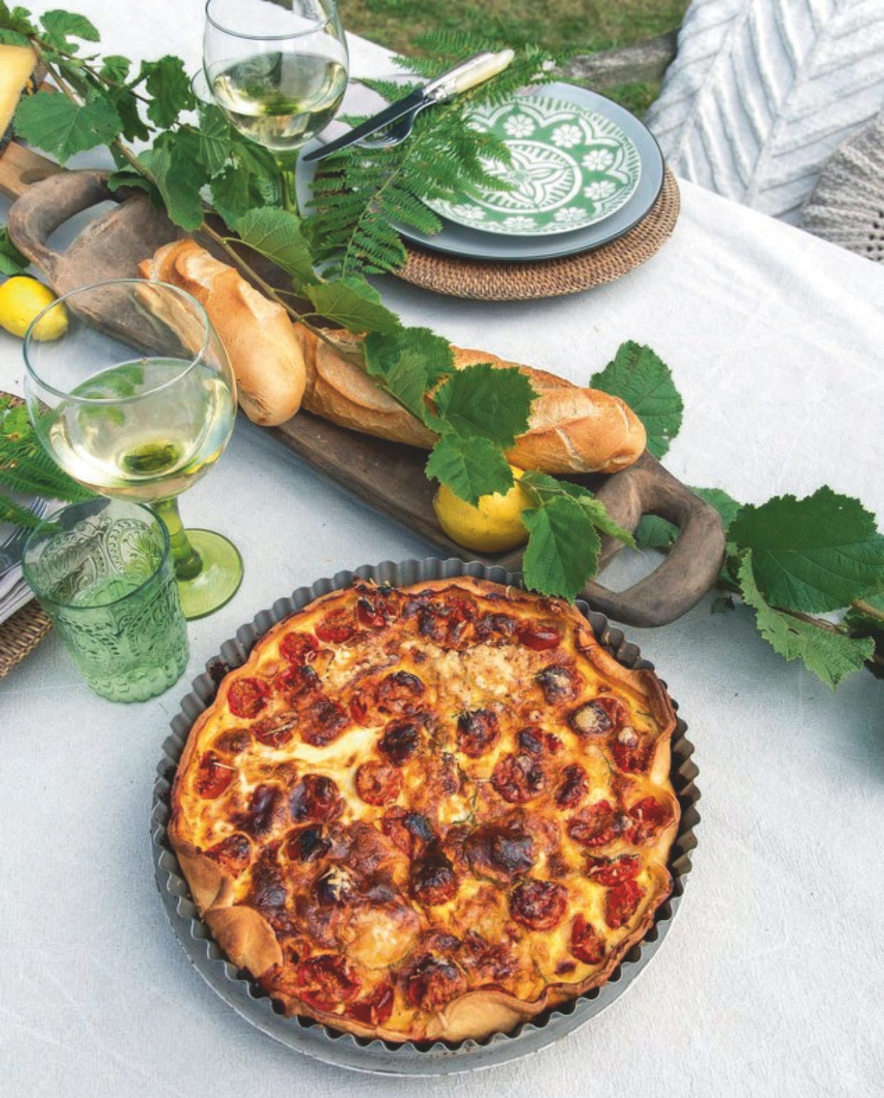 Waterglazen Villa Kakelbont, borden Xenos. Wijnglazen gekocht tijdens een vakantie in Spanje. Gecombineerd met wat groene takken uit de tuin krijgt zelfs een doordeweekse lunch het elan van een feestmaal. vtwonen Landelijk 2-2025 | styling Peet Styling! | fotografie Joyce Vloet | tekst Marie Masureel