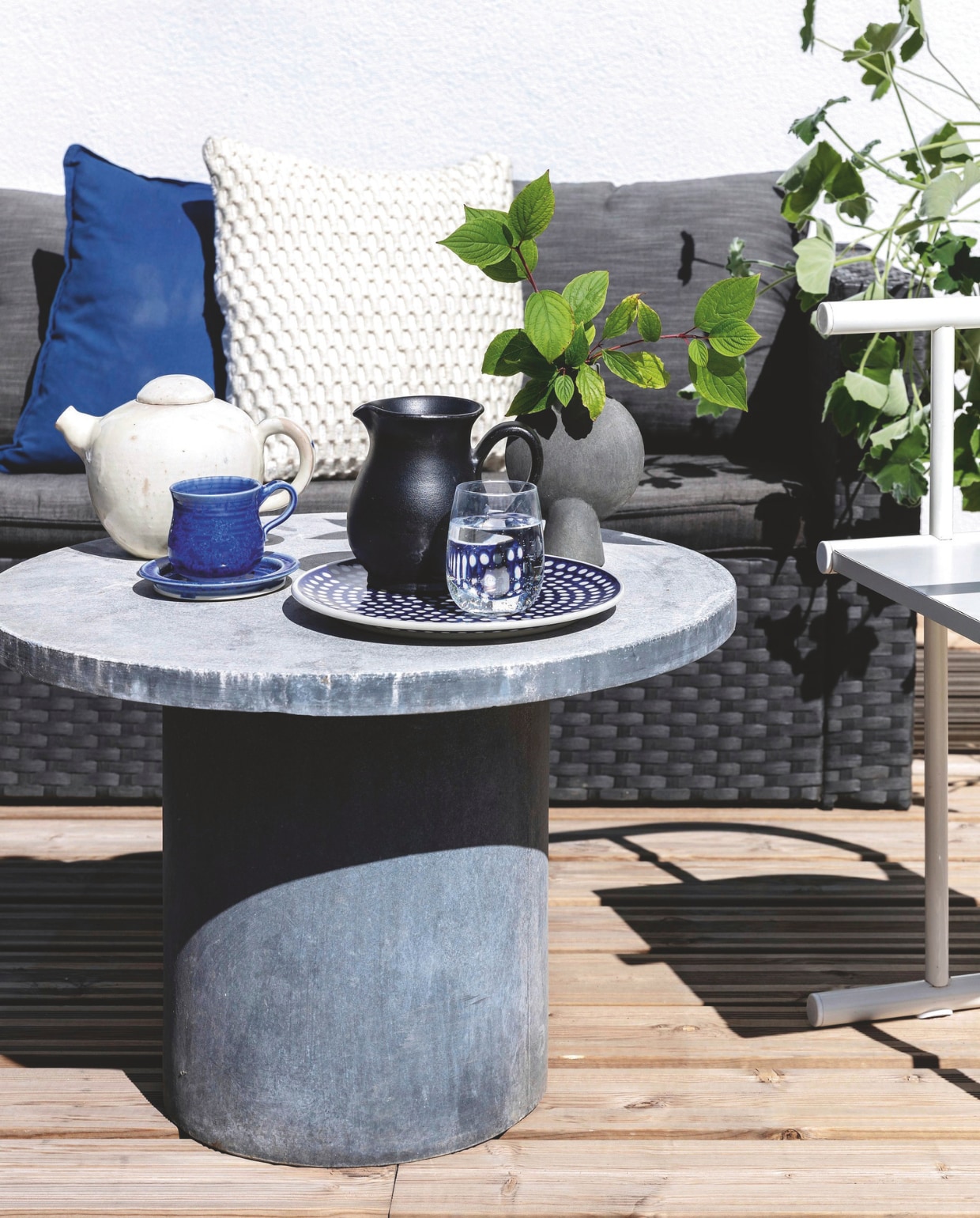 Betonnen tafel House Doctor. Vaas van 101 Copenhagen, kan, theepot, kop-en-schotel kringloop, bord van het Poolse Ewa &amp; Co. vtwonen tuin 11 | productie living inside | styling en tekst rikke graff juel | fotografie christina kayser o. | tekst ina babbé