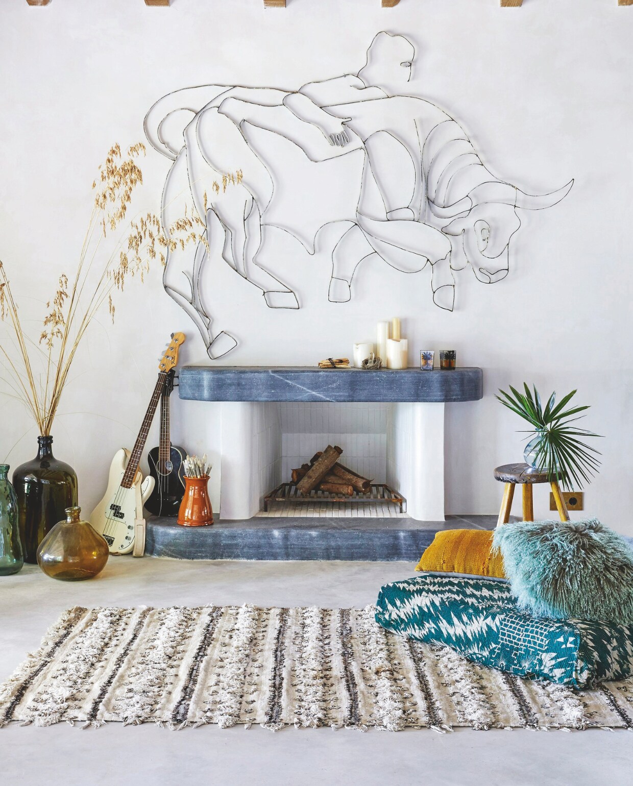 Nieuw gebouwde open haard, afgewerkt met kwartsiet, dat ook werd gebruikt voor het aanrecht. Kunstwerk uit de collectie van Paul. Traditionele Mallorcaanse opslagflessen voor wijn en olijfolie van lokale vlooienmarkt. Wollen Berbertapijt tijdens vakantie meegenomen uit Marrakech. vtwonen 02-2025 | Styling Tille Del Negro | Fotografie Greg Cox | Tekstbewerking Wilma Tjalsma-Smits