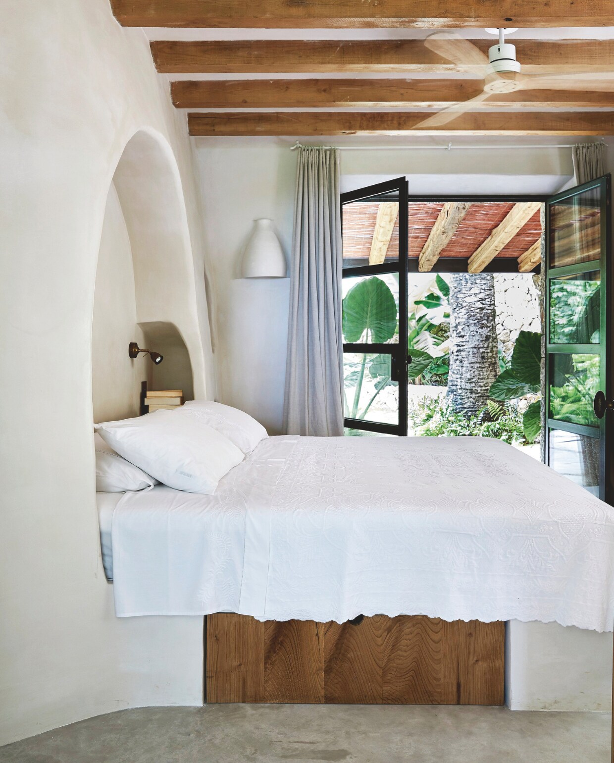Geen overbodige decoraties in deze serene slaapkamer. Sprei gekocht in het nabijgelegen stadje Sóller, soortgelijke subtiel gedecoreerde spreien La Redoute. vtwonen 02-2025 | Styling Tille Del Negro | Fotografie Greg Cox | Tekstbewerking Wilma Tjalsma-Smits