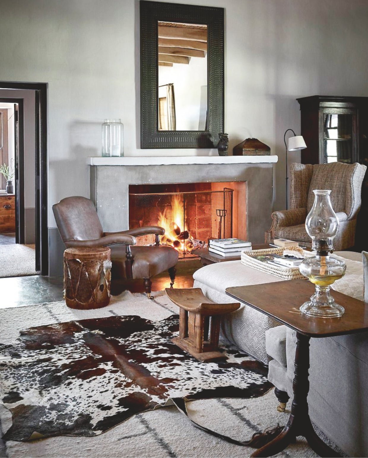 De woonkamer is gewenteld in natuurlijke tinten en texturen, met rieten manden, linnen hoezen, gebreide plaids, karakul wollen tapijten van Coral and Hive en nguni-huiden, soortgelijke Out of Africa Interiors. vtwonen landelijk 02-2025 | styling Luanne Toms | fotografie Elsa Young