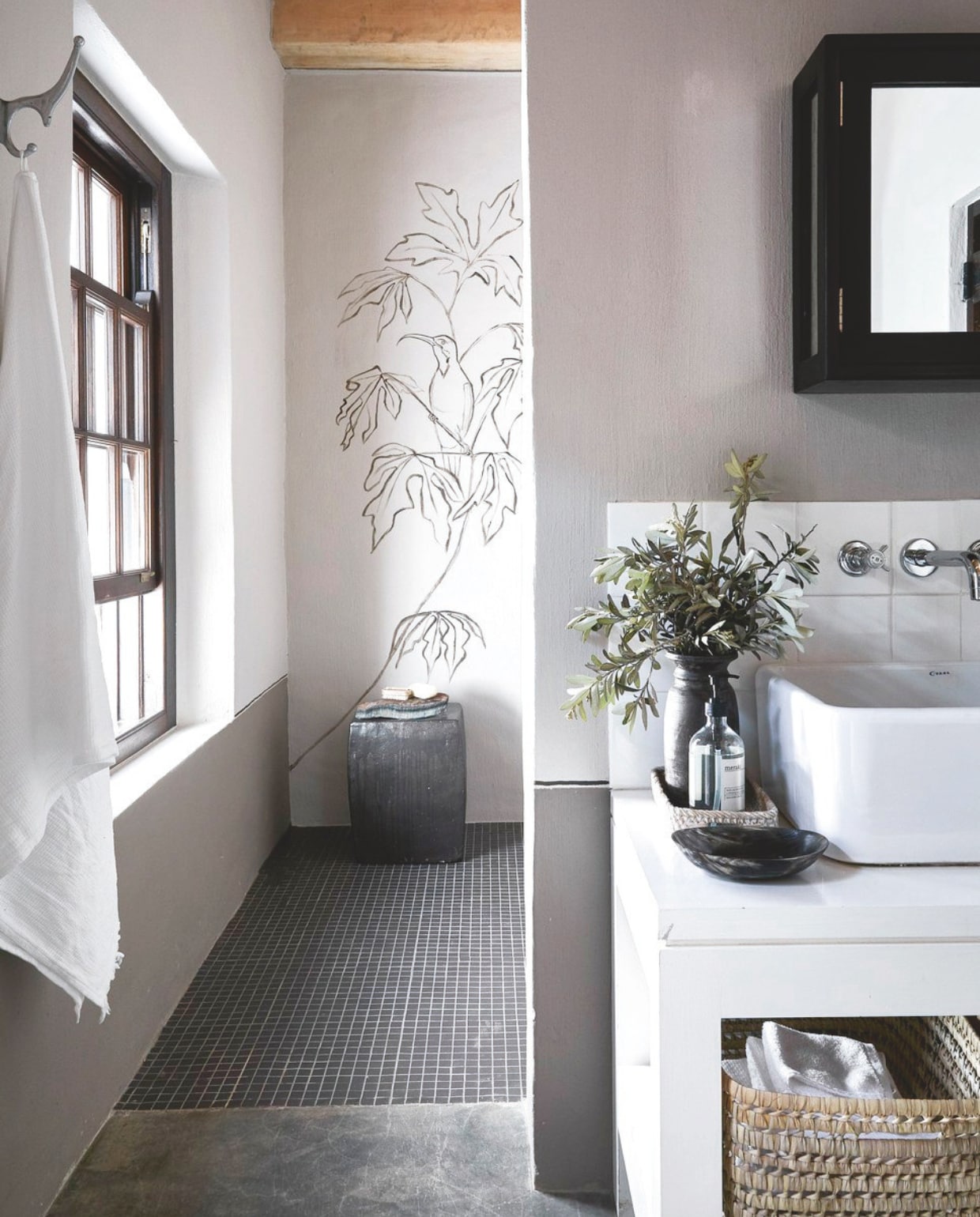 ‘De subtiele lijntekening op de wandin de douche brengt je in tropische sferen. Door de blaadjes uit de tekening te herhalen met echt groen in een vaas op het wasmeubel, breng je de tekening tot leven.’ vtwonen landelijk 02-2025 | Styling Luanne Toms | Fotografie Elsa Young | Tekstbewerking Mirjam Rosema-Verhulst