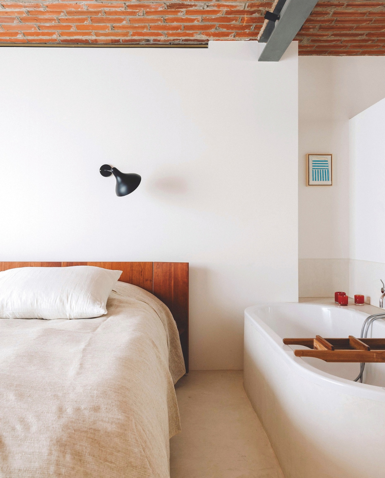 Onder de wandlamp Mantis van DCW staat een zelfontworpen bedwand. Ook de sprei op het bed is zelfgemaakt. Stijlvol Wonen 03-2025 | Fotografie Stie De Neve | Tekst Maya Toebat