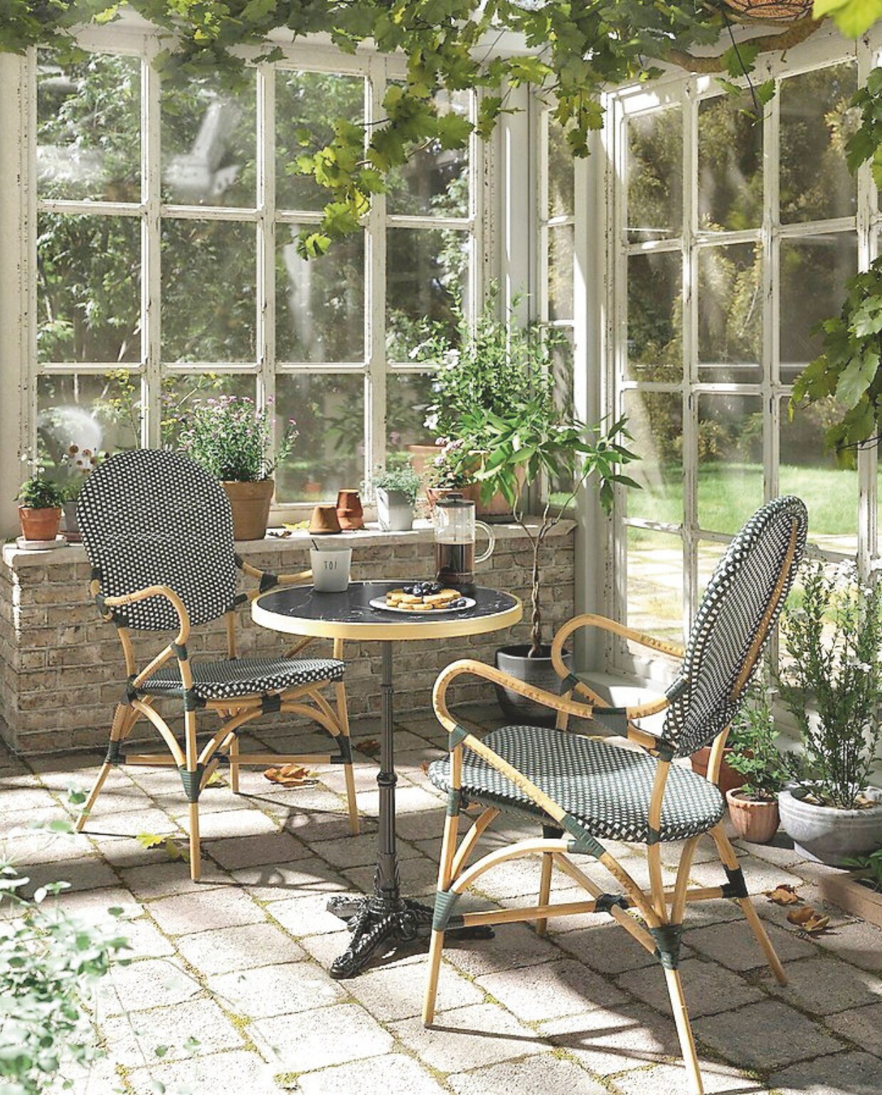 Rotan tuinfauteuil Bistro, 56,5x64,5x96 cm (bxdxh)€ 199,- en tuintafel Bistro, marmer en gietijzer, 57x71 cm (Øxh) € 279,- (laredoute.nl). Overig onbekend. vtwonen Landelijk 02-2025 | Beeld La Redoute