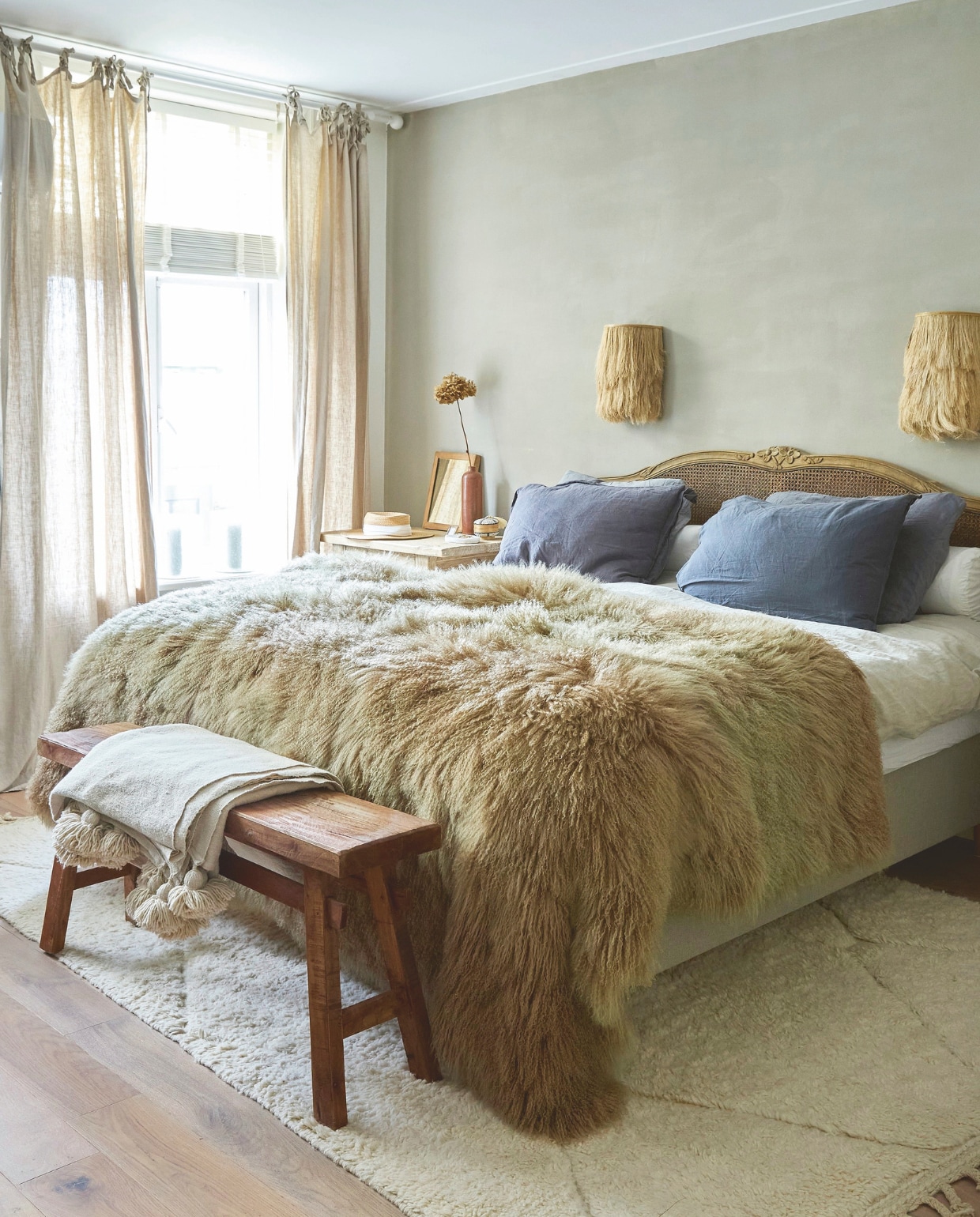 Wollen vloerkleed Zoco Home. Headboard en rol-kussens ML Fabrics. Linnen beddengoed By Mölle en Zara Home. Eiken parketvtwonen. Sidetable en raffia wandlampen viaMeisjes van Steen.
