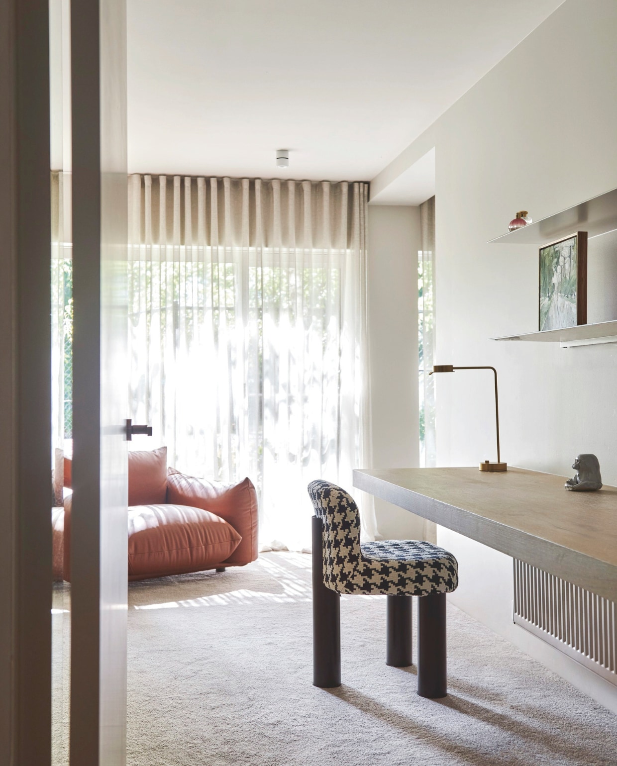 Stoel Botolo met pied-de-poule- dessin en fauteuil Maremo van Arflex. Het bureau is op maat gemaakt. Lamp Chipperfield van Euroluce. Krijtwit tapijt van Whitecliffe. vtwonen stijlvol 03-2025 | fotografie Lisa Cohen | tekst Tanne Donjacour Gielen | productie Living agency