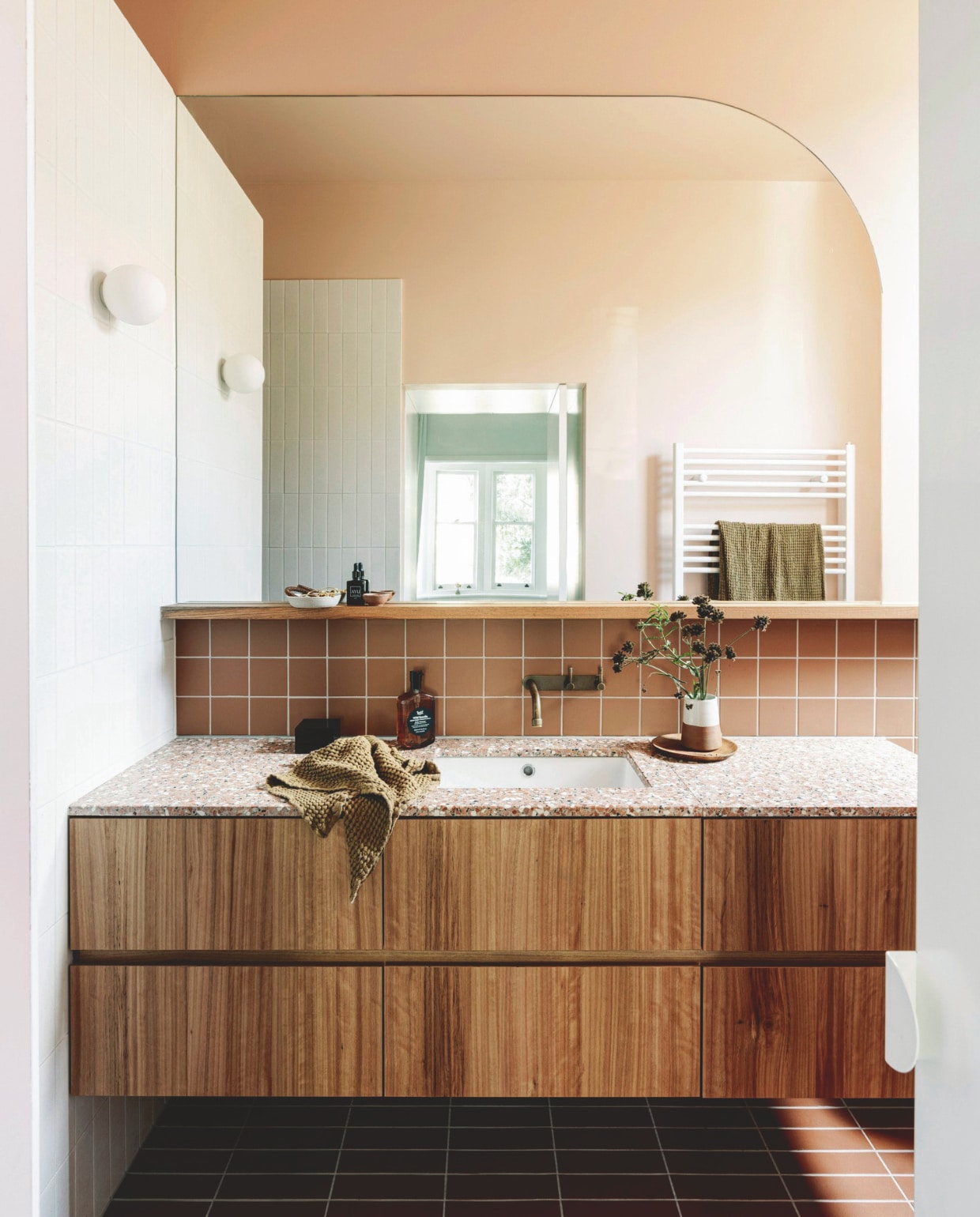 Blackbutt-fineer wastafelmeubel en spiegel ontworpen door Imogen Pullar Architecture, gebouwd door J&RC Builders. Terrazzo blad van Fibonacci. Kraan Brodware. Wandlamp Dioscuri van Artemide. Vloertegels Perini. Muurtegels De Fazio Tiles & Stones. Douchetegels Hida van Academy Tiles. Verf muur en plafond Maiko van Dulux. vtwonen 03-2025 | styling Belle Hemming | fotografie Marnie Hawson