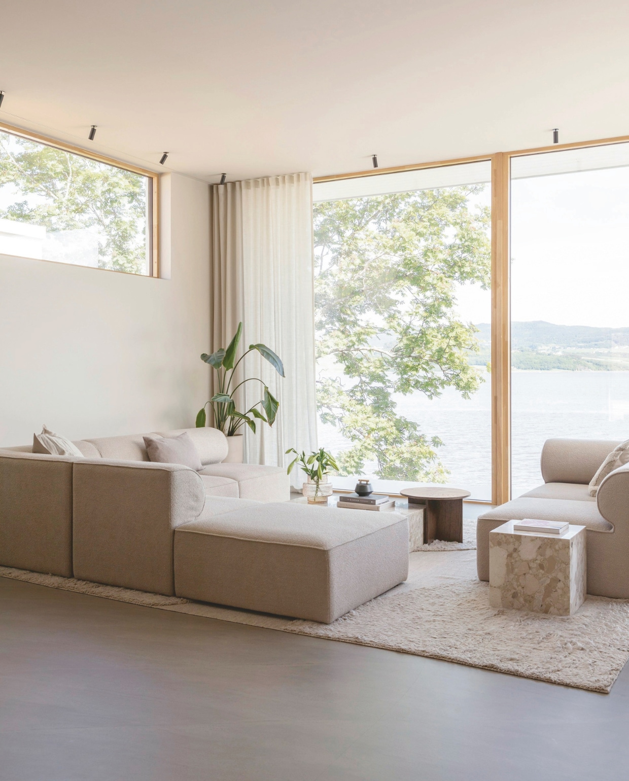 Modulaire bank Eave en bijzettafels Plinth Low en Androgyne van Audo Copenhagen. Kleed Punja Plasma van Layered. Gordijnen Albert Vold Interiør. Muurverf Gentle Whisper van Jotun. De Weber Designgulv vloer in de woonkamer en keuken bestaat uit een cement- en steenmix. Stijlvol Wonen 03-2025 | Fotografie Anne Bråtveit | Tekst Caroline Westdijk