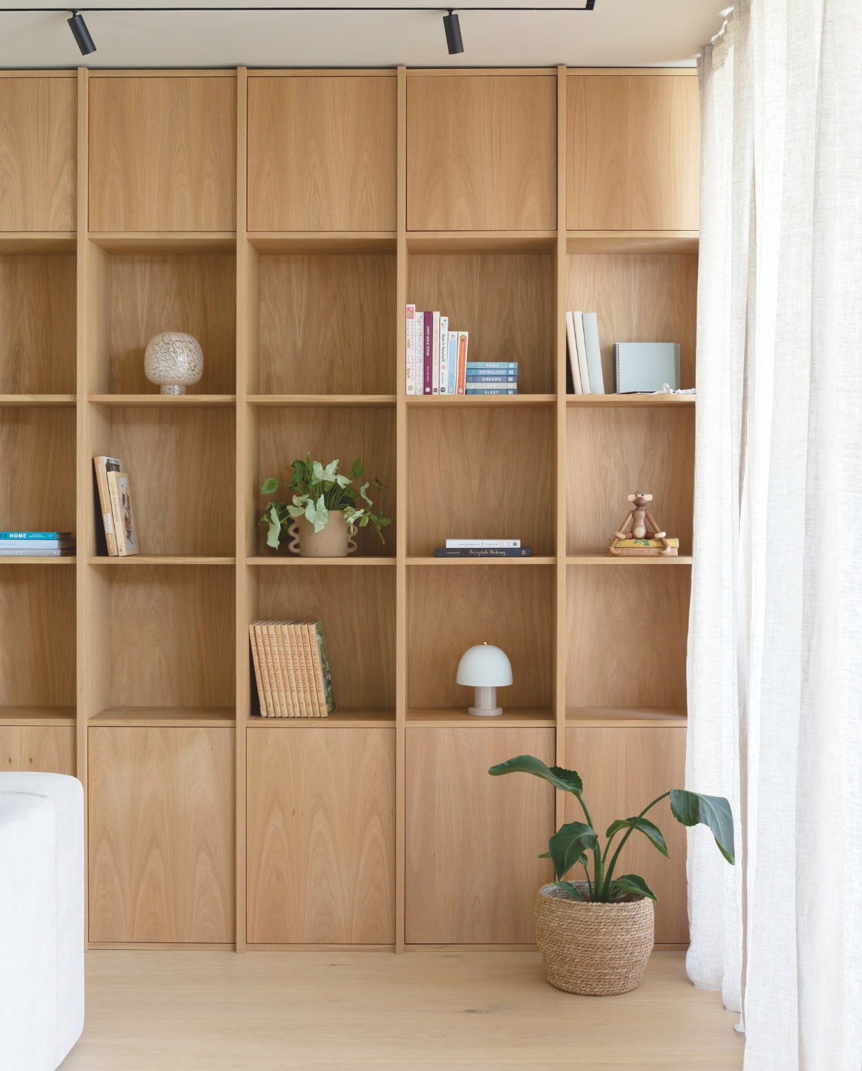 De tv-kamer is op dezelfde verdieping als de woonkamer en keuken. De boekenplank is op maat gemaakt door Fjellby en heeft zowel boven als onder verborgen opbergruimte. Plantenpotten Søstrene Grene. Stijlvol Wonen 03-2025 | Fotografie Anne Bråtveit | Tekst Caroline Westdijk