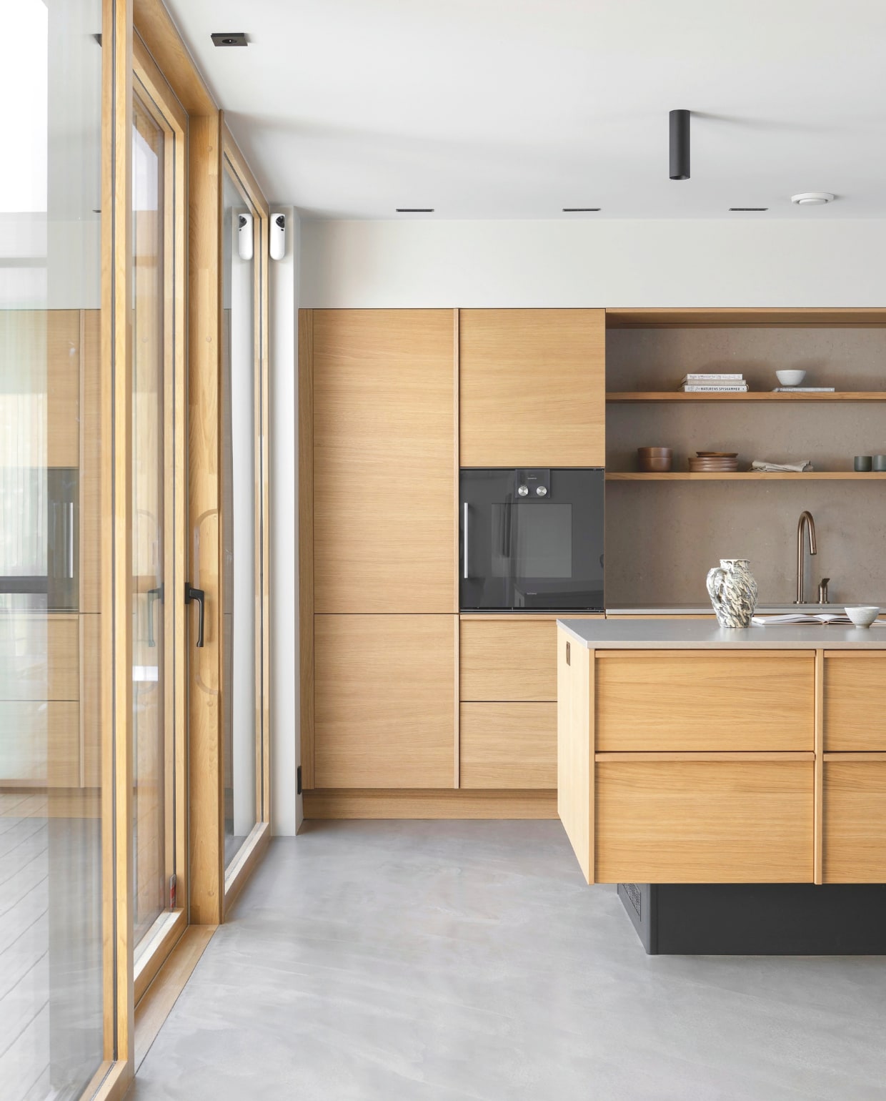 Keukenkasten en keukeneiland van  Fossline met een Silestone blad en spatwand. Apparaten Gaggenau. Keukenkraan Axor. Kan Nørr &amp; Leo. Witte keramieken kom Tybo Art and Craft. Groene koffiekopjes van Anette Krogstad via Norway Designs. Stijlvol Wonen 03-2025 | Fotografie Anne Bråtveit | Tekst Caroline Westdijk
