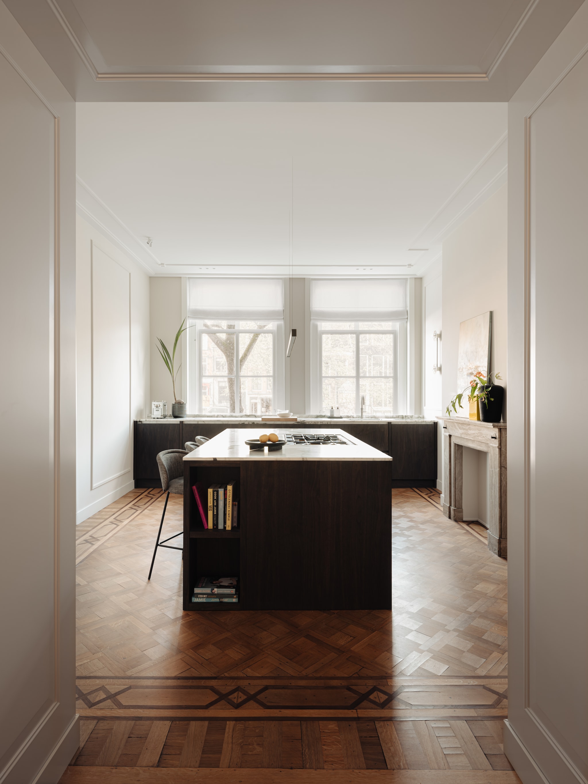 Het oorspronkelijke intarsia-parket in de keuken kon blijven. Maatwerk keuken Kluster Interieurbouw. Natuursteen House of Stone. Barkrukken Freifrau Manufaktur. Hanglamp Anour. Spots Wever & Ducré. Gordijnen Designs of the Time. Muurverf Elephant’s Breath van Farrow & Ball. Lijstwerk Het Schippertje. vtwonen 06-2025 | fotografie Mart Goossens