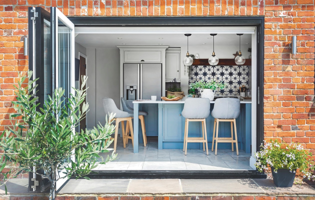 Vergelijkbare harmonicapui Solarlux. Op maat gemaakte keuken Handmade Kitchens in Kent. Vergelijkbare barkrukken Kave Home. vtwonen Landelijk 03-2025 | Fotografie Richard Gadsby | Tekst Roel Janssen