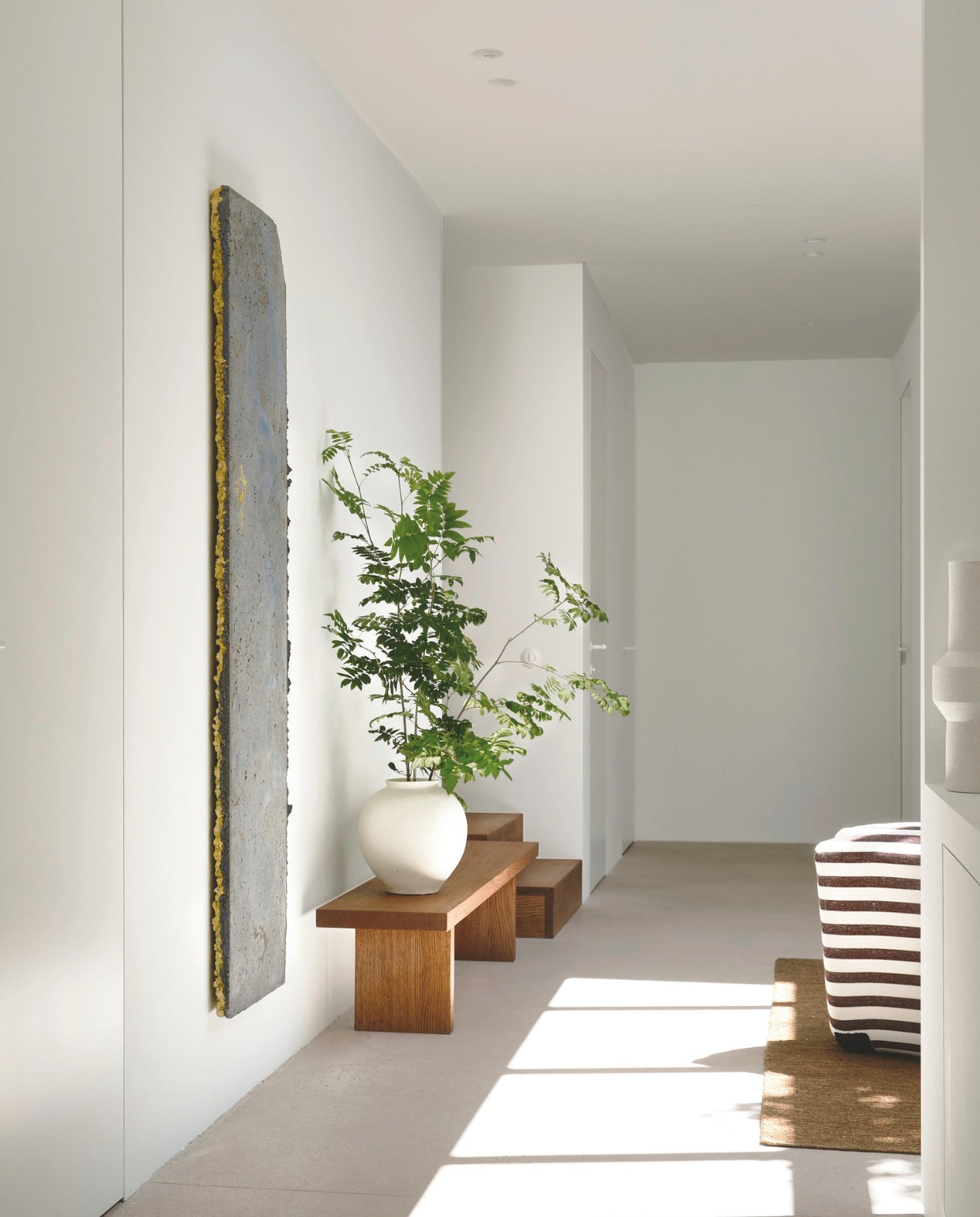 Het kunstwerk uit gekleurd beton aan de muur van Jef Meyer. Vaas Zara Home. stijlvol wonen | 2-2025 | fotografie Mr Frank | tekst Maya Toebat