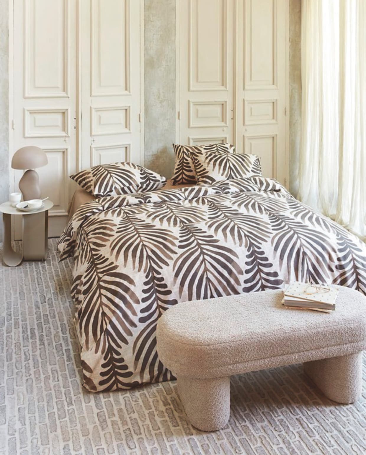 Katoenen dekbedovertrek Bold Feathers in Zand vanaf € 49,95. M.m.v. by-boo.com (nachtkastje, tafellamp, stoffen bank), kwantum.nl (mok en 
bord). Overig privébezit. vtwonen 04-2025 | styling Kim Timmerman, Danielle Verheul | fotografie Richard Smit