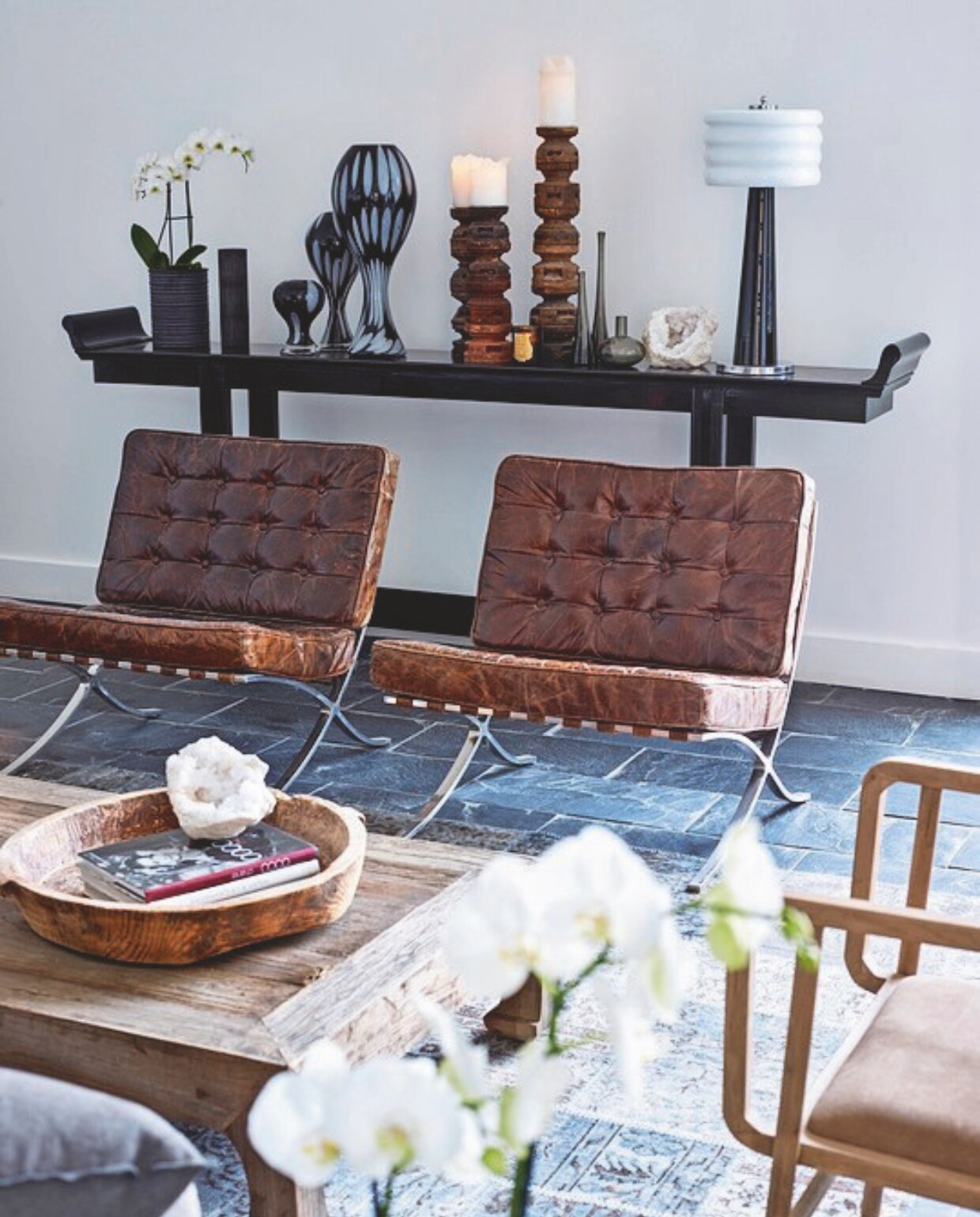 Leistenen vloer. Houten stoelen Kenas Home. Leren stoelen KnollStudio. Vergelijkbare wandkast Woood. Vergelijkbare pot Muubs. vtwonen landelijk 03-2025 | Styling José Spaans | Fotografie Sarah Van Hove