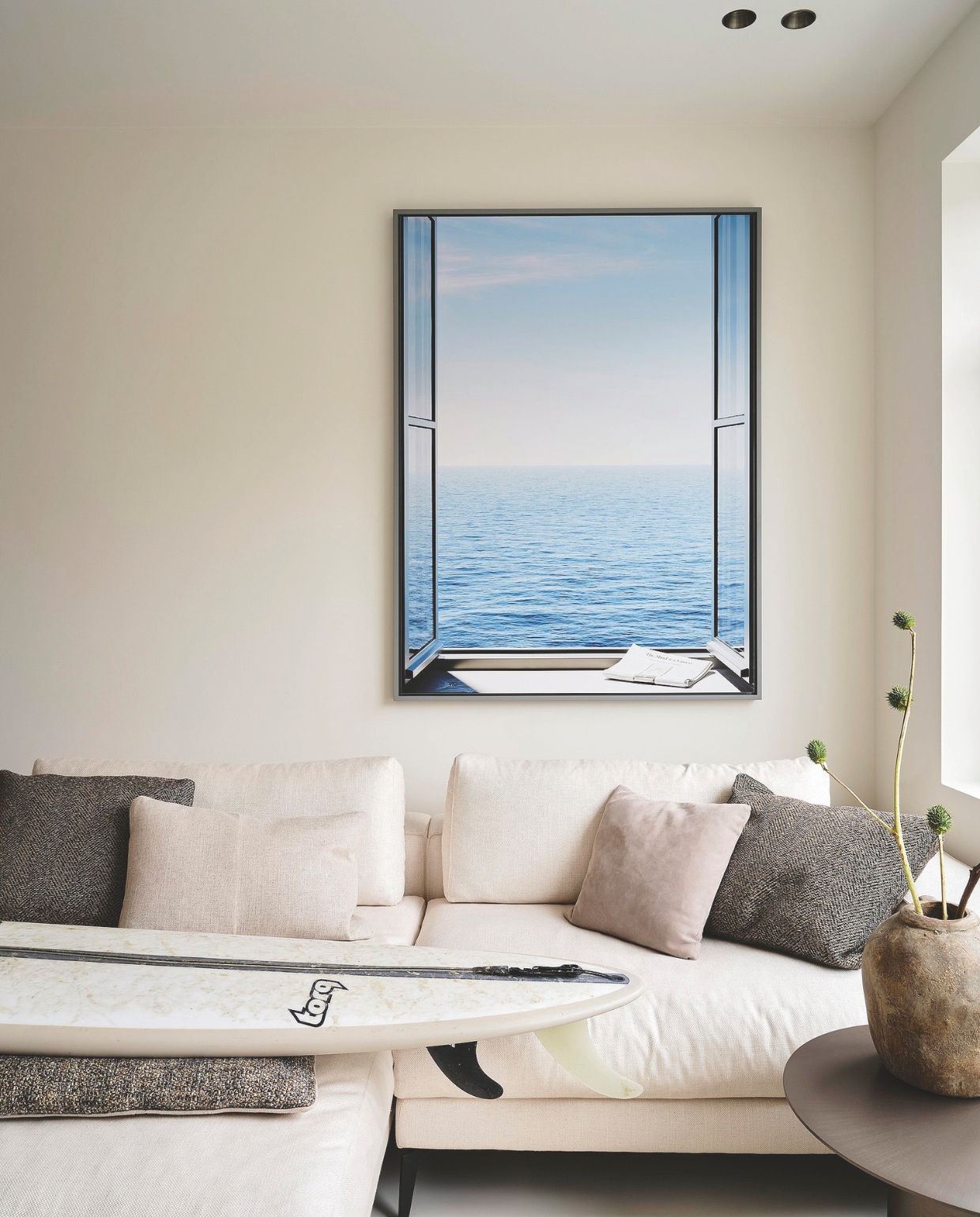 Bank Macazz. Bijzettafel en kussens Minotti. Het kunstwerk fungeert als trompe-l’oeil en is van de Italiaanse fotograaf Giuseppe Lo Schiavo. Surfboard Torq. vtwonen Stijlvol 4-2025 | Fotografie Space Content Studio | Tekst Eveline Stoel