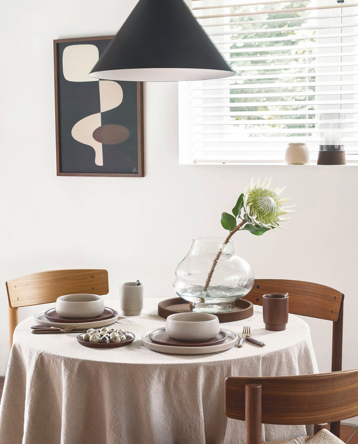 Keramieken ontbijtkom in Flax, 16 cm (Ø) set van 2 € 24,95, porseleinen mok in Bruin en Flax, 300 ml, set van 4 € 29,95, keramieken bord in Flax, 27 cm (Ø) € 24,95, keramieken bord in Bruin, 23 cm (Ø), set van 2 € 39,95 en 17 cm (Ø), set van 4 € 44,95, metalen opbergbox in Geel-Roze (links in het kozijn), diverse maten vanaf 12x10 cm (Øxh), set van 2 € 24,95, houten fotolijst, diverse afmetingen vanaf € 19,95. vtwonen 04-2025 | styling Kim van Rossenberg | fotografie Stan Koolen