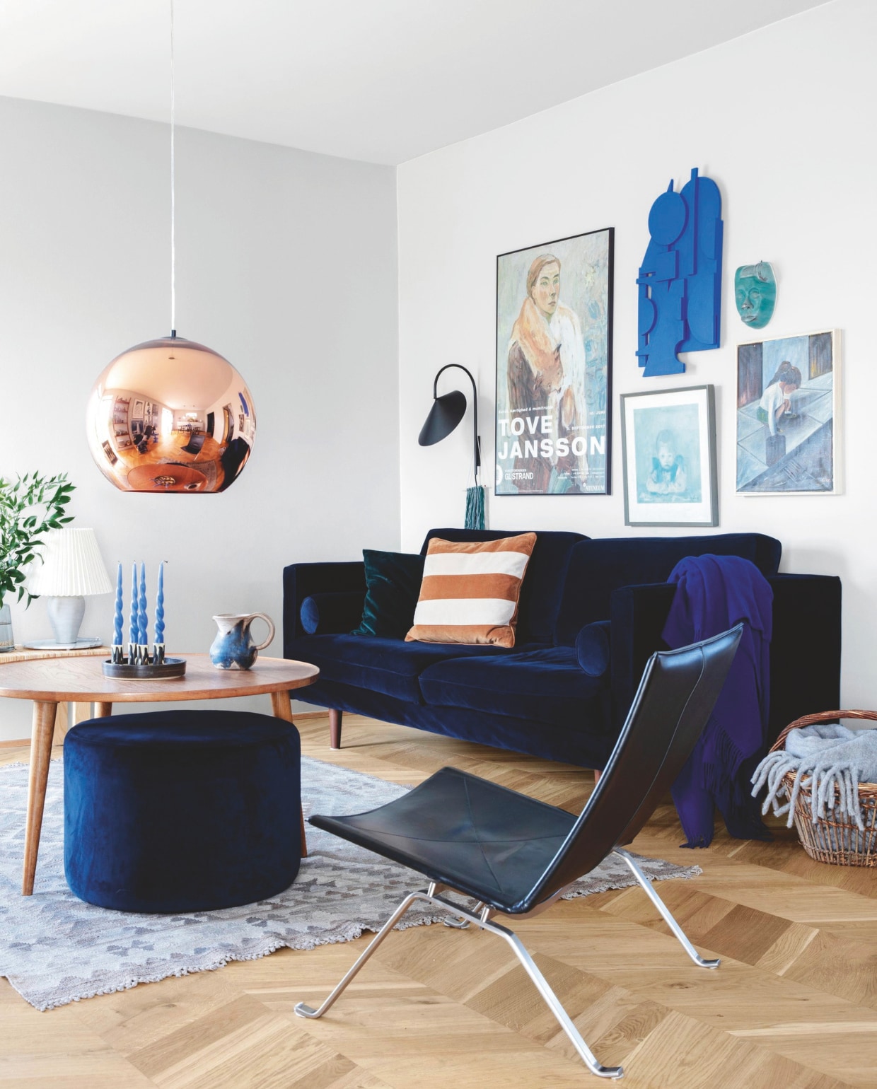 Bank en poef Sofacompany, plaid Silkeborg Uldspinderi. Wandlamp Ferm Living, hanglamp Tom Dixon. Kleed Tine K Home, zwarte stoel Poul Kjærholm. Accessoires kringloopvondsten. Wandsculptuur zelfgemaakt door Lone. Lichtgrijze muur- en plafondkleur NCS S 2000-N vtwonen 04-2025 | styling Rikke Graff Juel | fotografie Christina Kayser O.