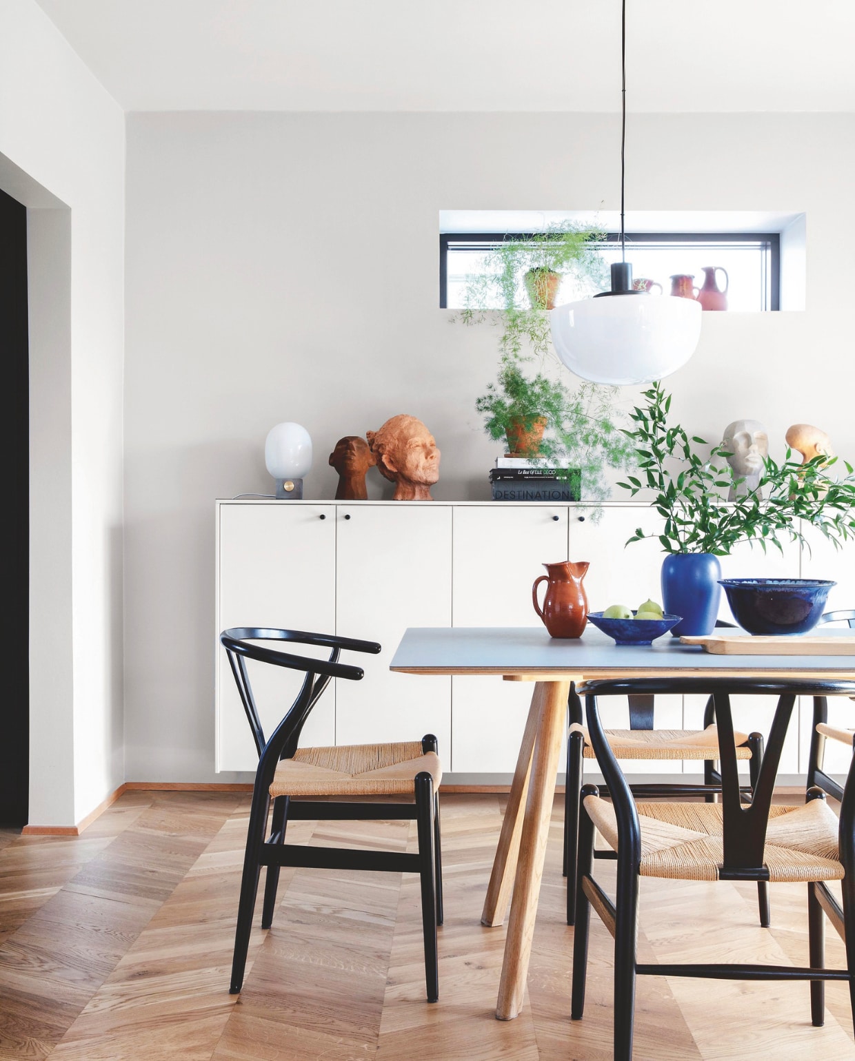 Eeetkamerstoelen Hans J. Wegner, tafel Hay, hanglampen Menu. Dressoir gemaakt van oude Ikea keukenkastjes, geverfd in een lichtgrijze kleur. Nieuwe deurknoppen van Grebkompagniet. vtwonen 04-2025 | styling Rikke Graff Juel | fotografie Christina Kayser O.