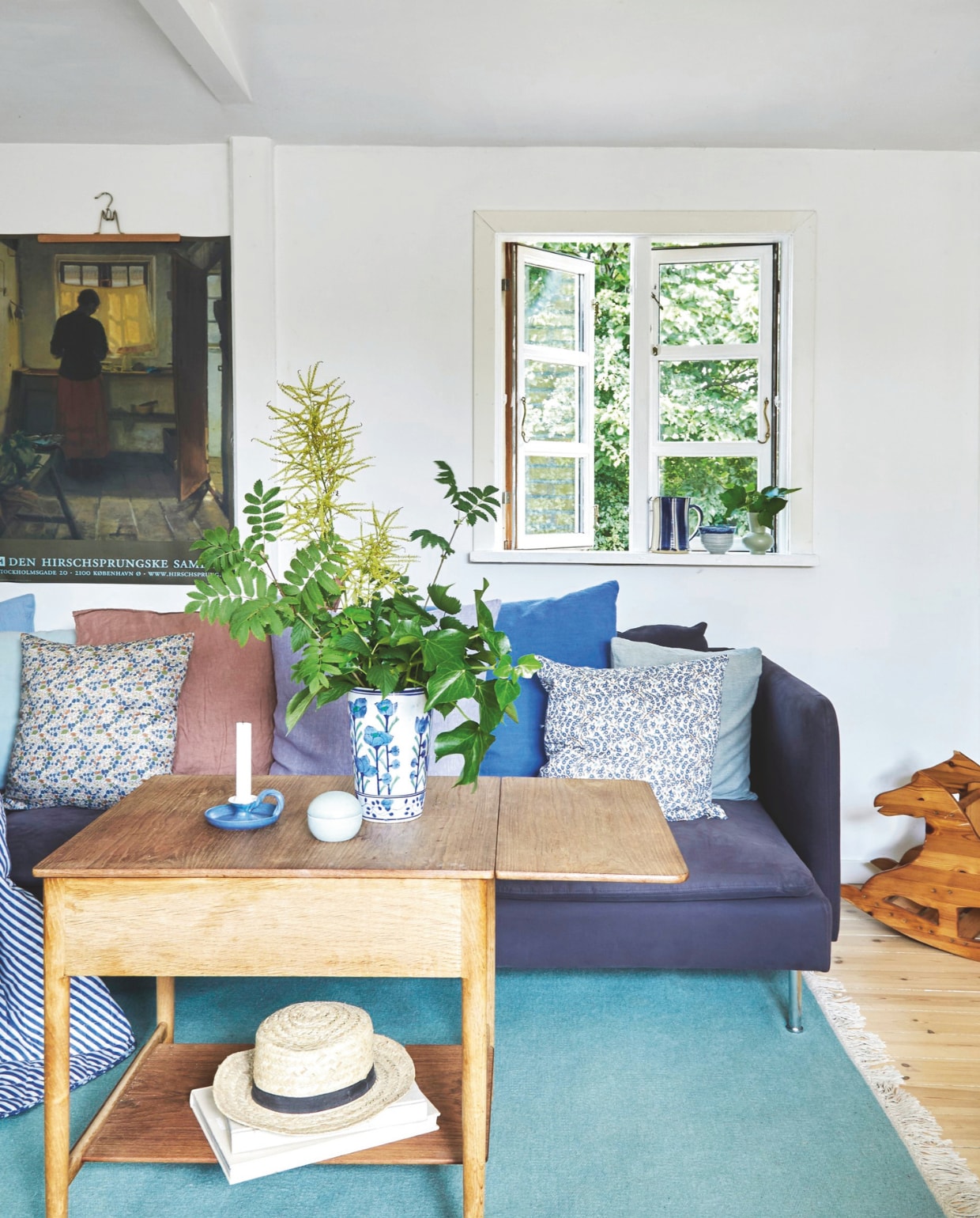 Bank Ikea. Kussens door Gitte gemaakt. Salontafel uitde vintagewinkel in Gilleleje. Vaas Saikindo Ceramics. De originele houten vloer is geschaafd en met loog behandeld. Het houten hobbelpaard komt uit Gittes familie. vtwonen Landelijk 4-2025 | Styling Rikke Graff Juel | Fotografie Anitta Behrendt | Tekst Wilma Tjalsma-Smits