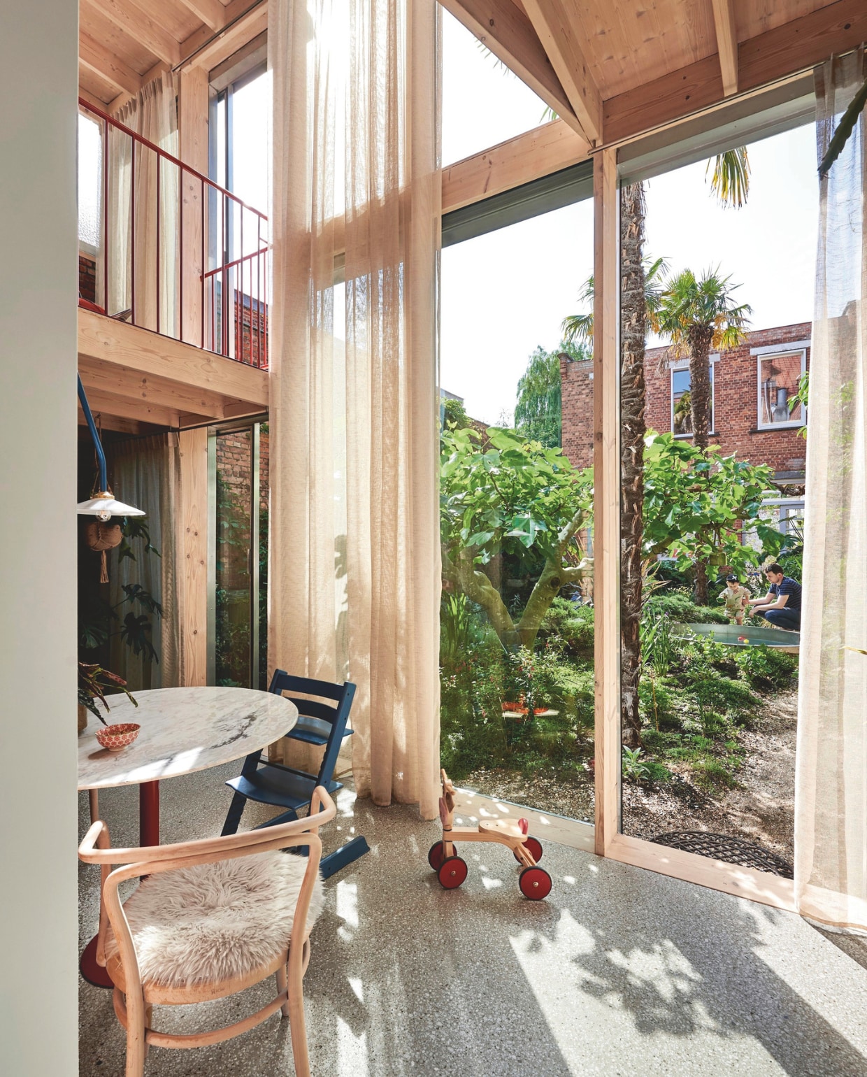 Vloer marmerbeton. Houten stoel 30 van Ton, blauwe stoel Stokke, tafel eigen ontwerp. Loopfiets tweedehands. Zitkussen Barbar.design. Lamp N2 van Muller Van Severen. vtwonen zomerboek 2025 | fotografie mr. frank