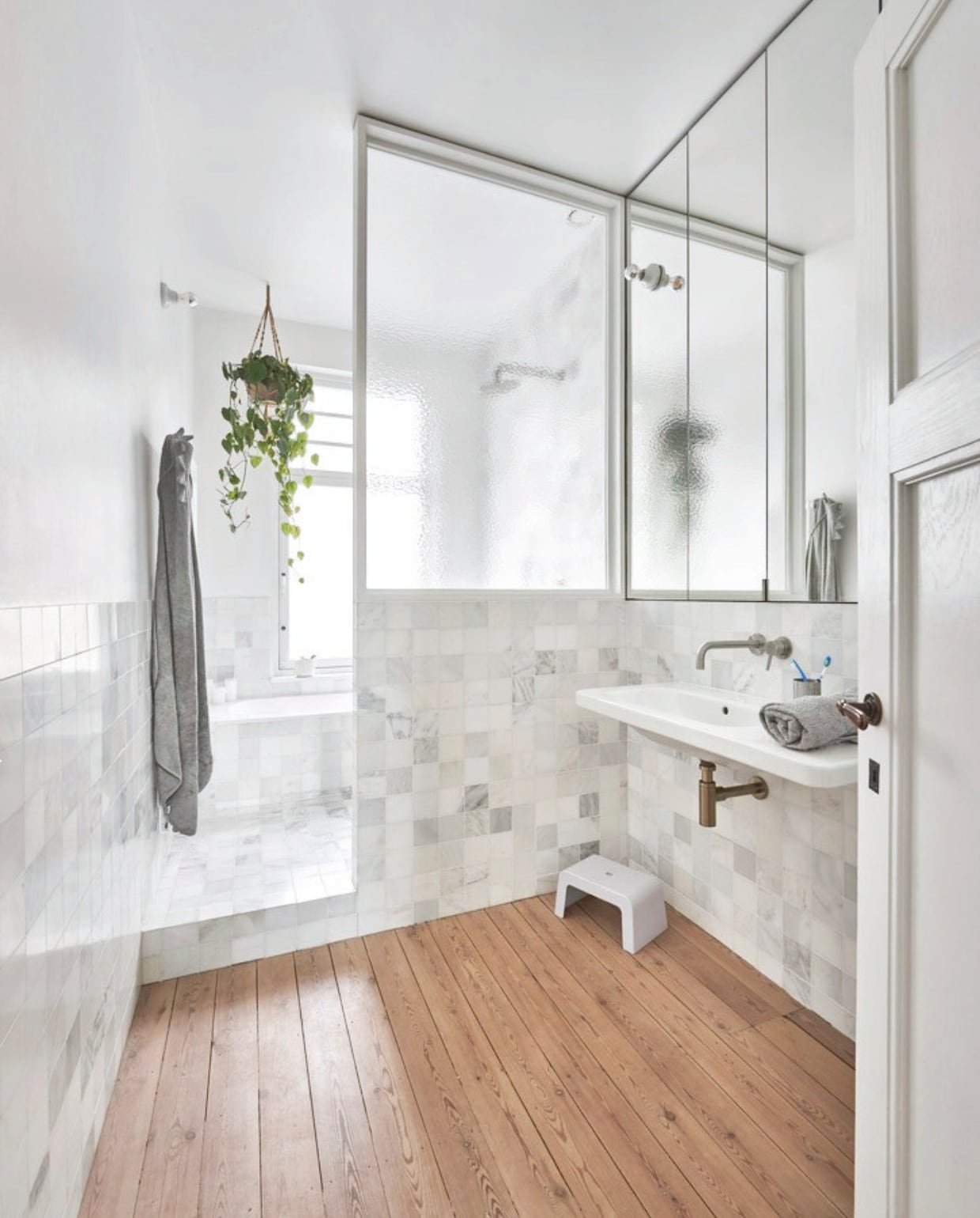 Houten vloer origineel en gerestaureerd. Tegels Old white van Hullebusch. Wastafel Duravit. Kruk en handdoek Liewood. Porseleinen wandlamp Zangra. vtwonen zomerboek | fotografie Mr. Frank | tekst Kyra Dirksen