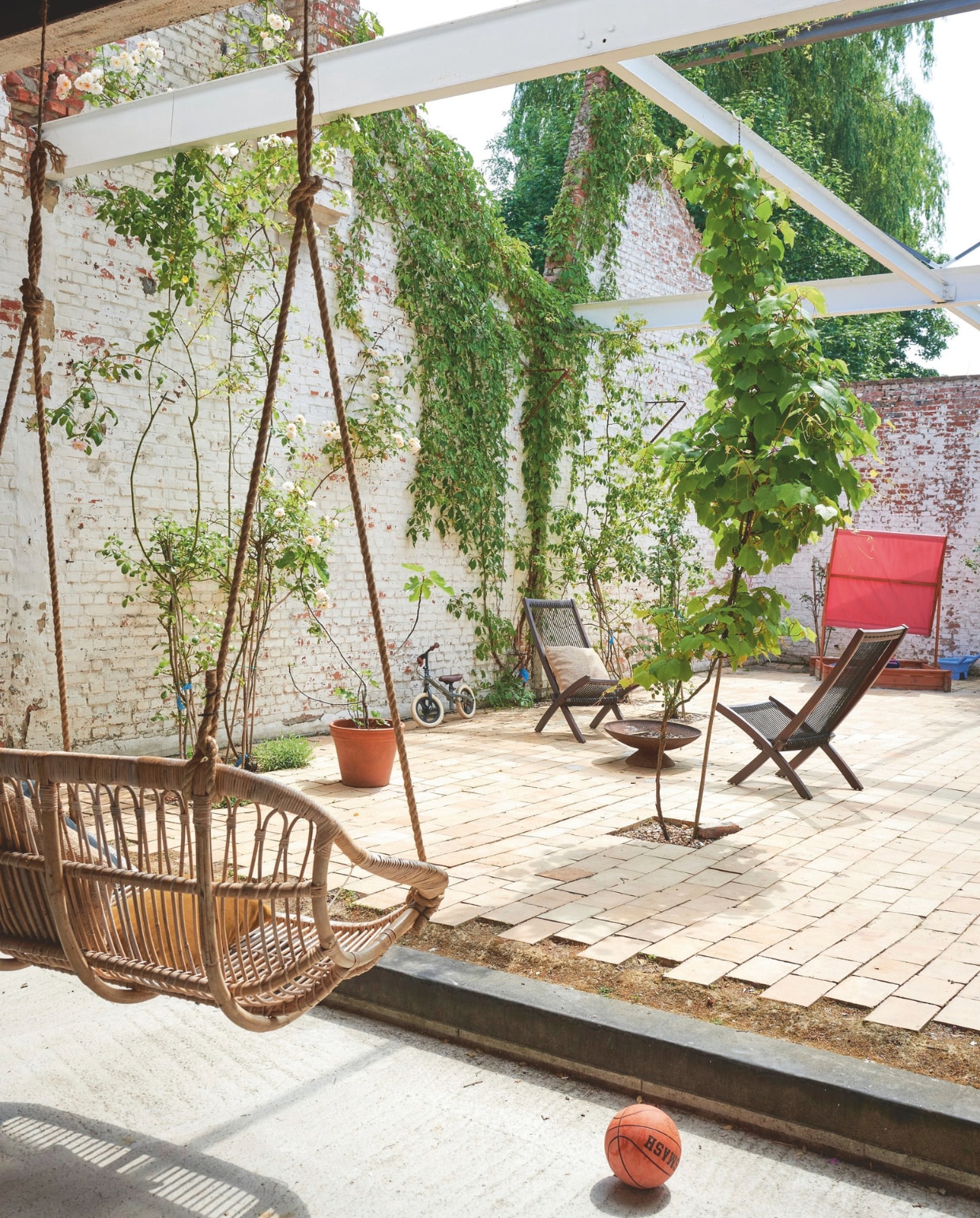 Rieten hangstoel Casa. Tuinstoelen Ikea, vuurschaal tuincentrum. Zandbak met zonnescherm Bol. vtwonen zomerboek | fotografie Mr. Frank | tekst Kyra Dirksen