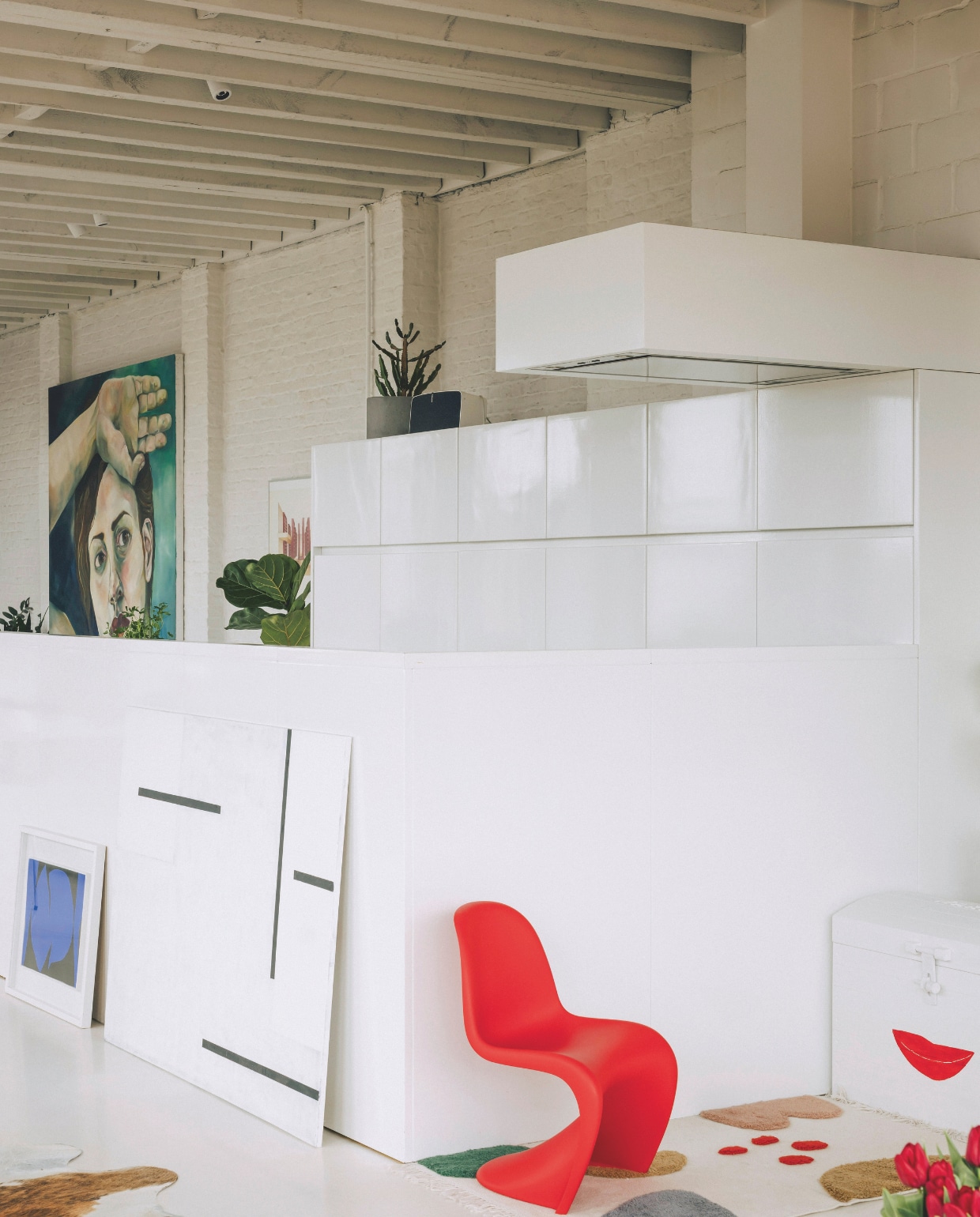 Naast de keuken heeft Maxence een speelhoekje, met een rode junior Panton Chair van Vitra, een tapijt van Liewood en een kist voor zijn speelgoed. Frédérique doet haar best om de kinderspullen esthetisch te laten aansluiten in de open ruimte. Stijlvol Wonen 05-2025 | fotografie Katoo Peeters