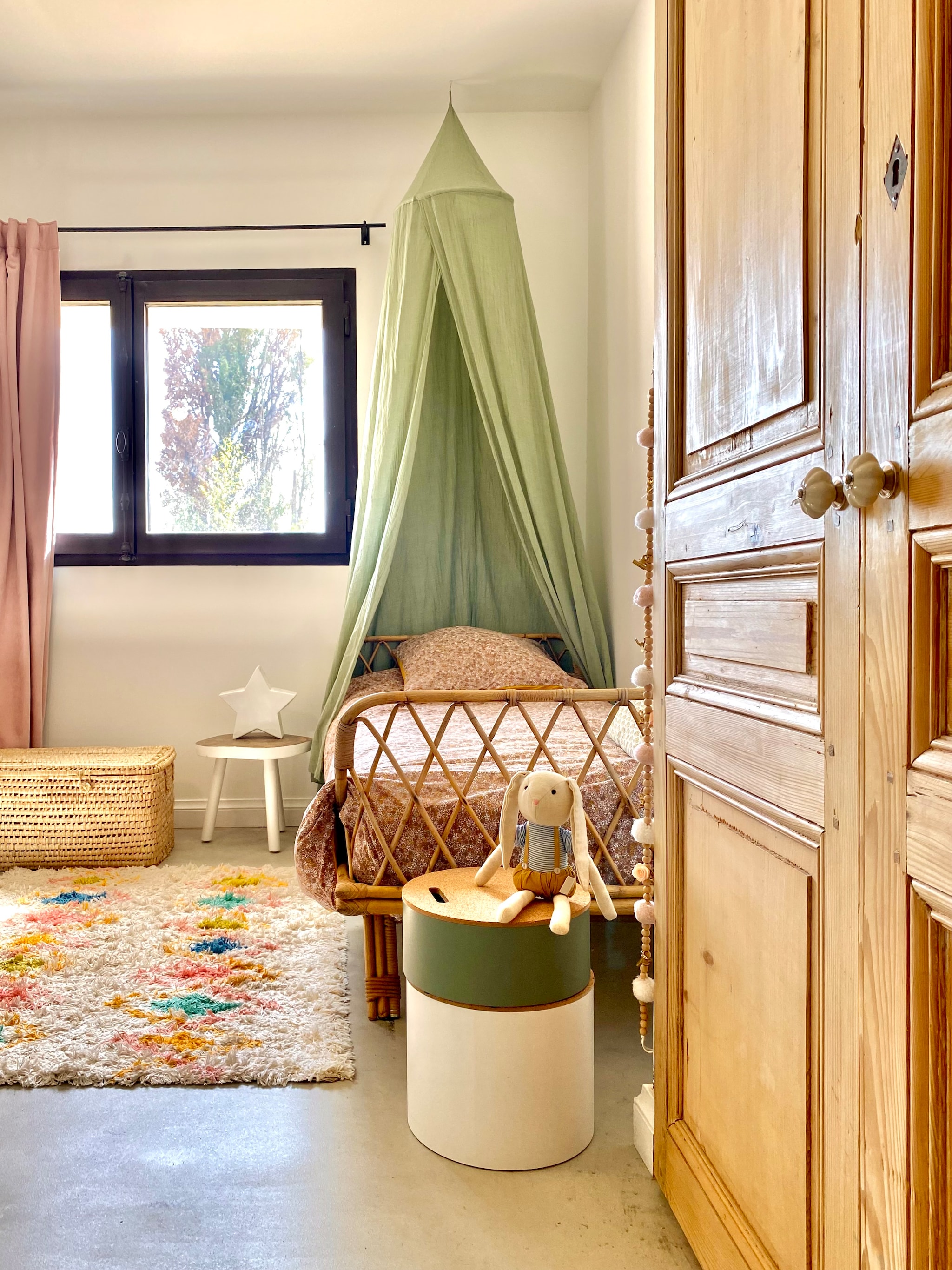 Rotan bed en kast vintage, hemel Casa. Vloerkleed La Redoute, hanglamp Am+Pm. Tipi en ronde opbergdozen Alinea. vtwonen 07-2025 | fotografie Manon Ferra
