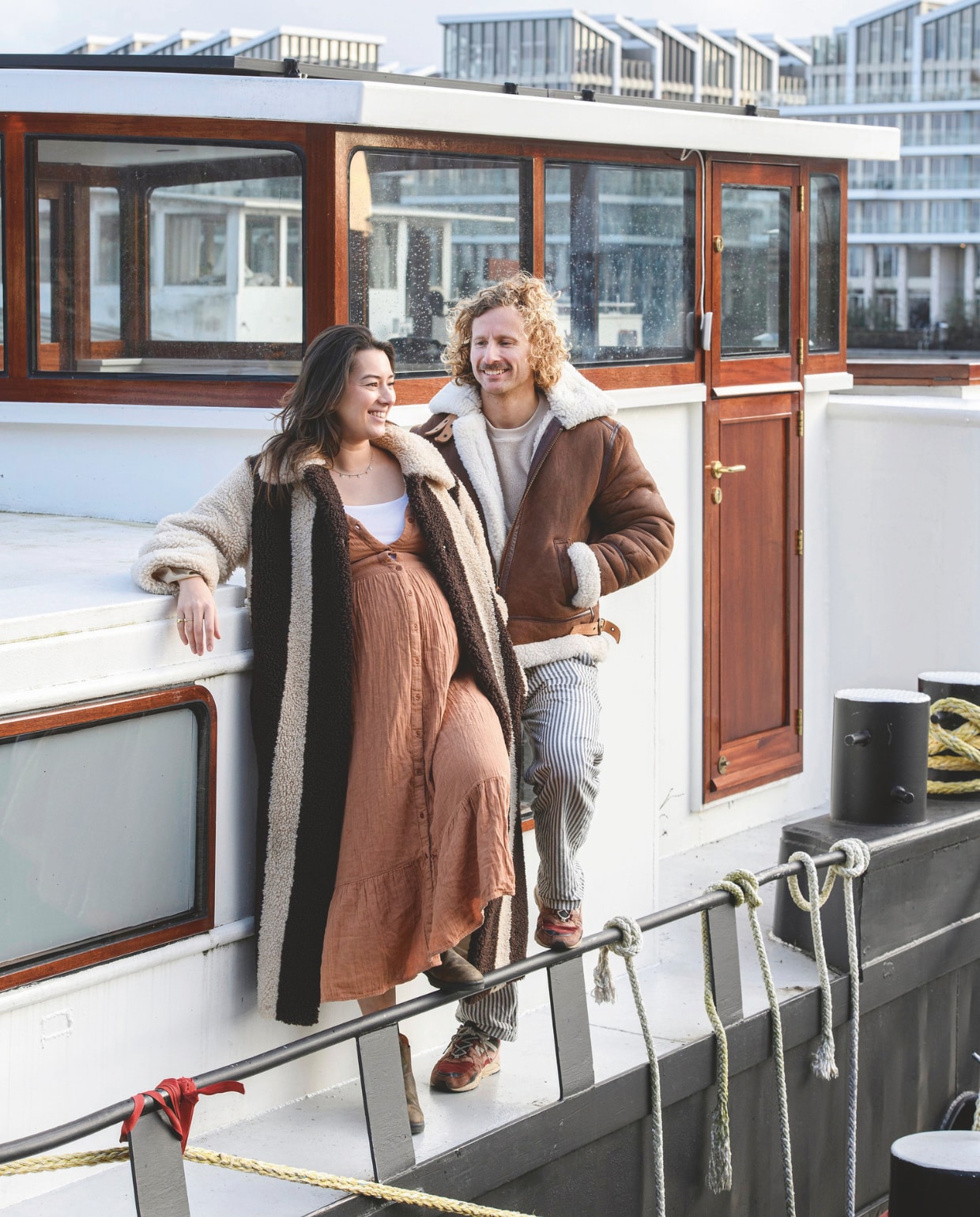 Jelle en Anna op hun schip in Amsterdam, dat ze samen met David Koel van Woodies Shipbuilding Amsterdam transformeerden tot woning. De kozijnen en deuren zijn van mahoniehout en krijgen elk jaar een lik beits.* Terracotta Warrior vtwonen 05-2025 | styling Marit Saladini | fotografie Louis Lemaire | tekst Jackie Oomen