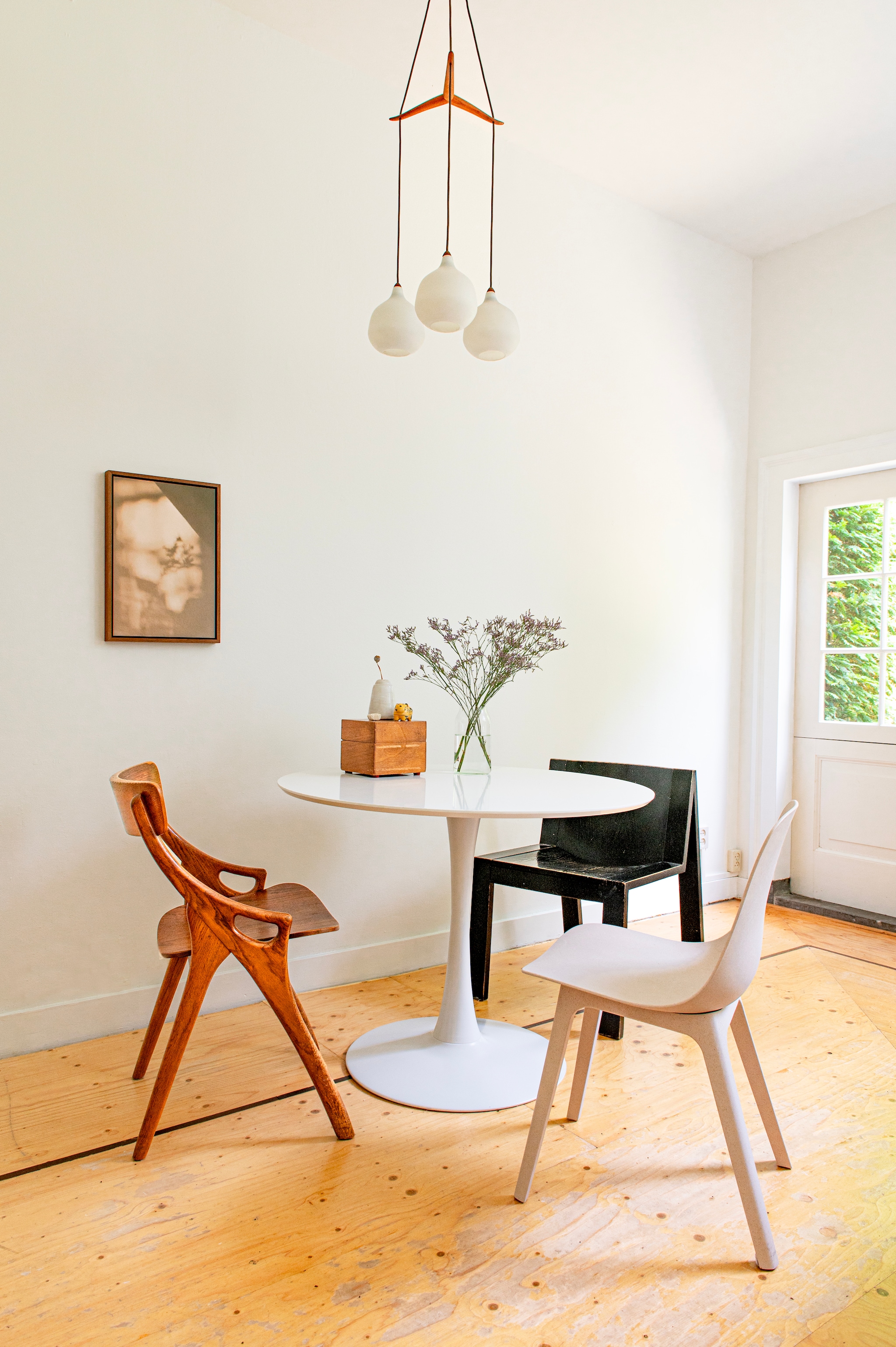 Kunstwerk Delusion van Floortje Louise, vintage hanglamp Sprinkelhop. Eettafel Ringsted van Jysk. Jaren 50-stoel van Arne Hovmand- Olsen en zwarte stoel uit jaren 70 van Pastoe uit kringloopwinkels. Stoel Odger van Ikea. Kist van Franse markt. 	vtwonen diy special | styling Jeske Weel | fotografie Caroline Coehorst