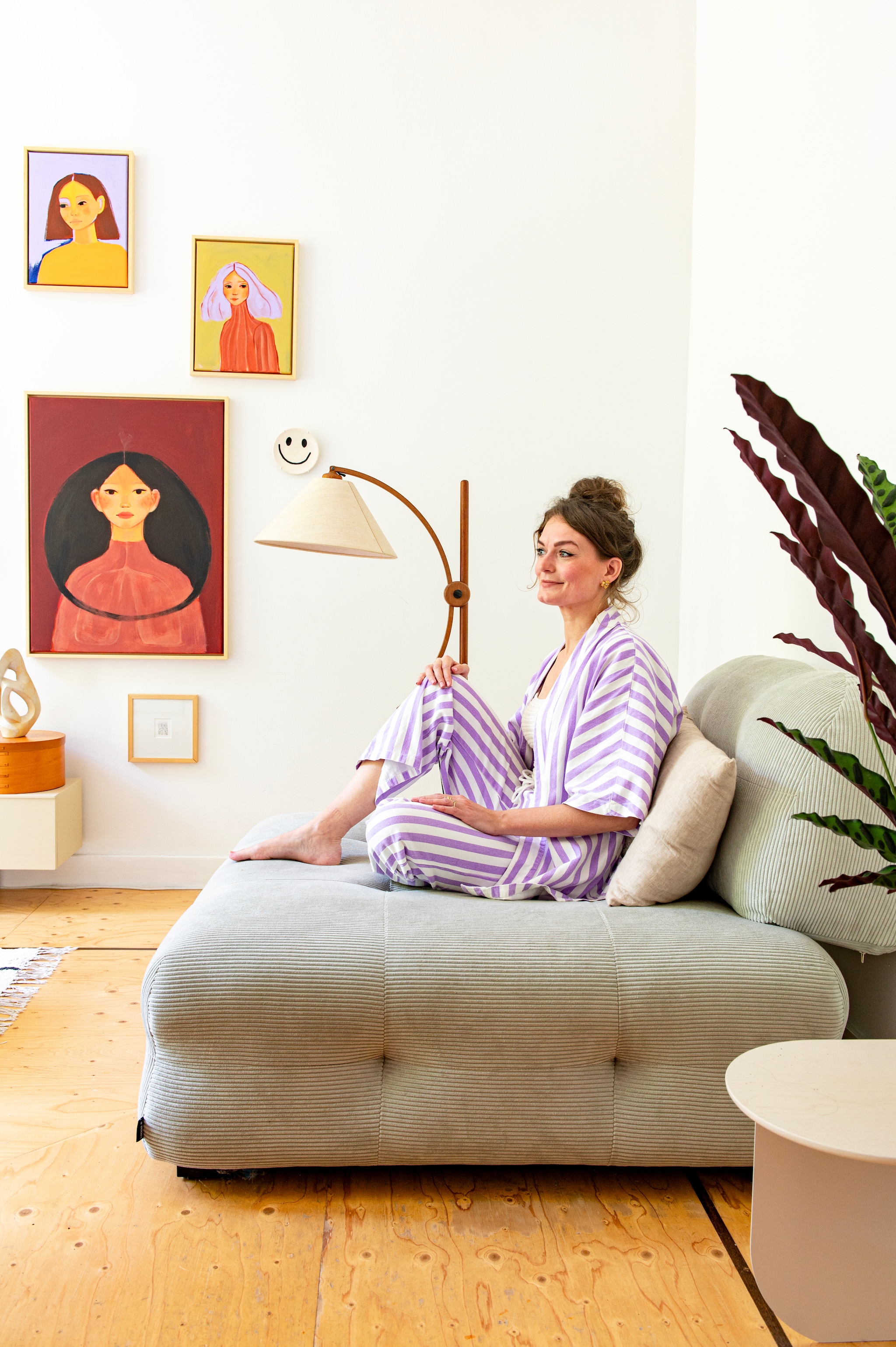 Bank Gayle van Karwei, vloerkleed Sissy-Boy. Salontafel Tintin en bijzettafel Plateau van Fést. Fauteuil en kaarshouder Loods 5. Vintage vloerlamp Sprinkelhop. Tv-meubel HKliving, tv The Frame van Samsung. Windlicht kokosnoot Atelier Sukha. Zoutlamp en sculptuur uit kringloopwinkel. Schilderijen gemaakt door Iris, smiley-bordje The Clay Shaper, print Milou Trouwborst, wandsculptuur Lydia Elisabeth Pottery. 	vtwonen diy special | styling Jeske Weel | fotografie Caroline Coehorst