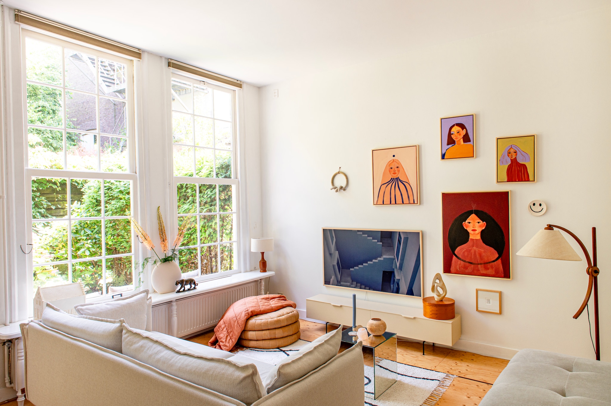 Bank Gayle van Karwei, vloerkleed Sissy-Boy. Salontafel Tintin en bijzettafel Plateau van Fést. Fauteuil en kaarshouder Loods 5. Vintage vloerlamp Sprinkelhop. Tv-meubel HKliving, tv The Frame van Samsung. Windlicht kokosnoot Atelier Sukha. Zoutlamp en sculptuur uit kringloopwinkel. Schilderijen gemaakt door Iris, smiley-bordje The Clay Shaper, print Milou Trouwborst, wandsculptuur Lydia Elisabeth Pottery. 	vtwonen diy special | styling Jeske Weel | fotografie Caroline Coehorst