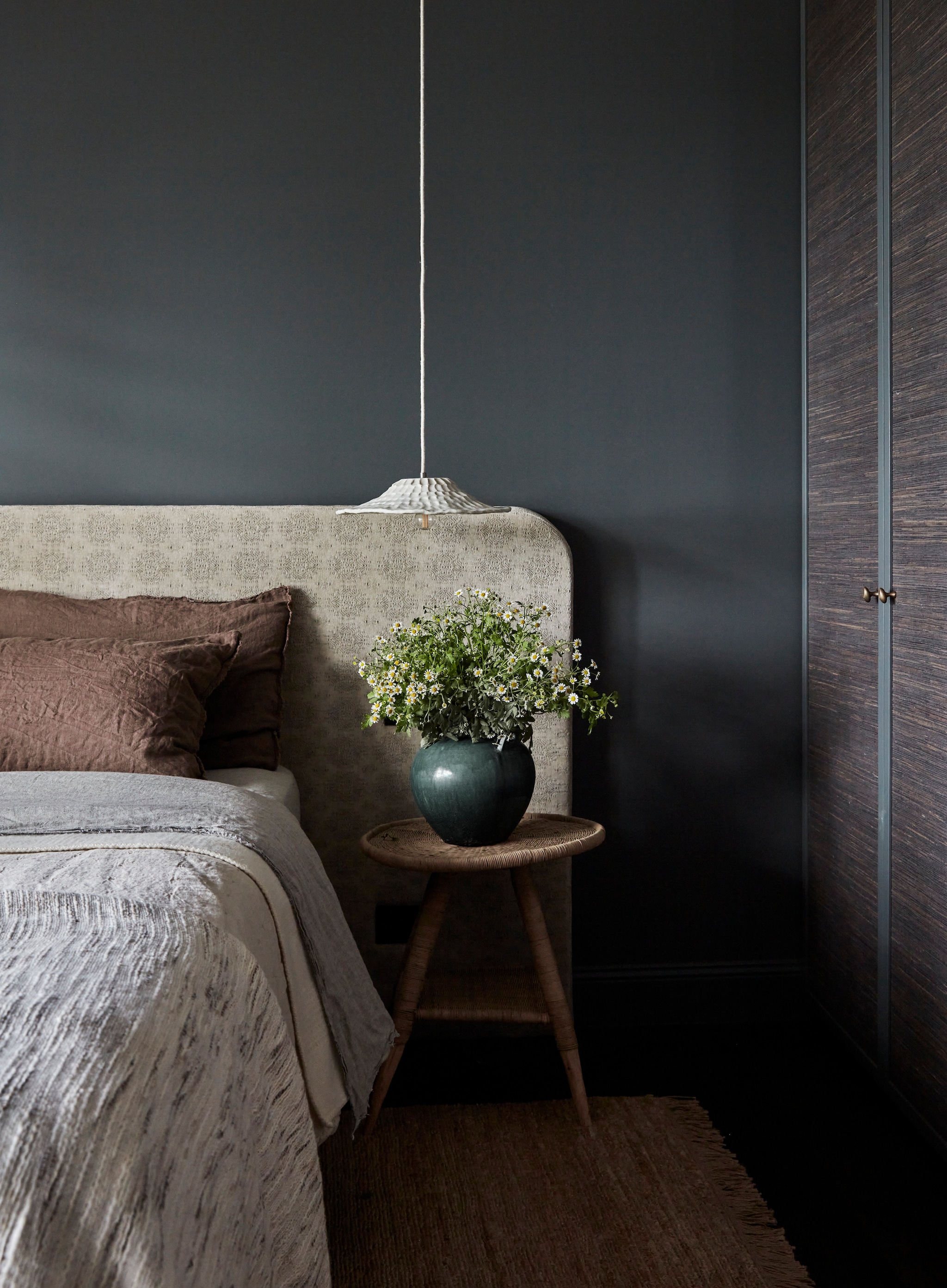 Hoofdbord gemaakt door Louise Walsh met stof van Maison de Vacances. Bed King Koil. Kruk Malawi van Orient House. Lamp Mayclay Ceramics.  Muurkleur Juvenile van Dulux. Geweven juten behang op kledingkast  van Twenty2. Juten vloerkleed Mojave van Armadillo. vtwonen Landelijk 07-2025 | styling Louise Walsh | fotografie Maree Homer  | productie Living Inside