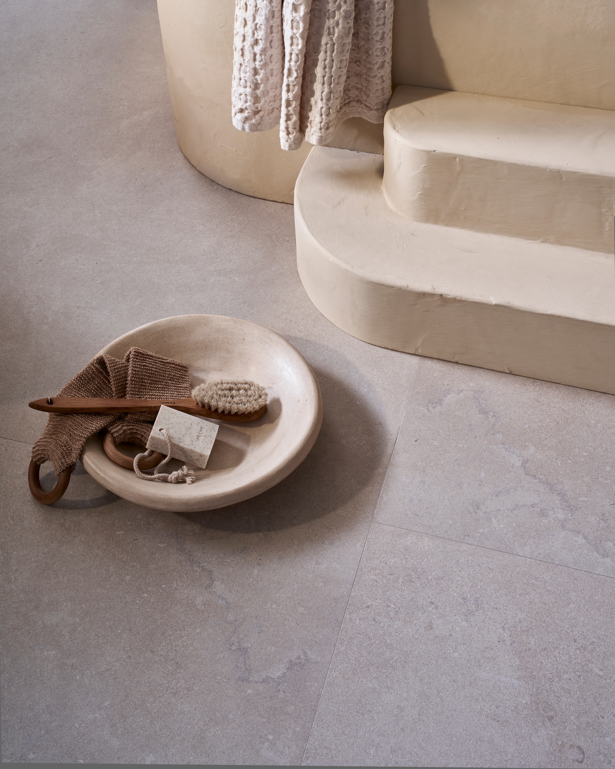 vtwonen tegel Portland Travertine in Marfil 120x280 cm, per m2 € 99,50. weldaad.com (houten pot en vaas), urbannatureculture.com (katoen-maché pot), zarahome.com (handdoeken), householdhardware.nl (schaal van tadelakt). Overig privébezit. vtwonen Landelijk 07-2025 | fotografie Jeroen van der Spek | styling Cleo Scheulderman