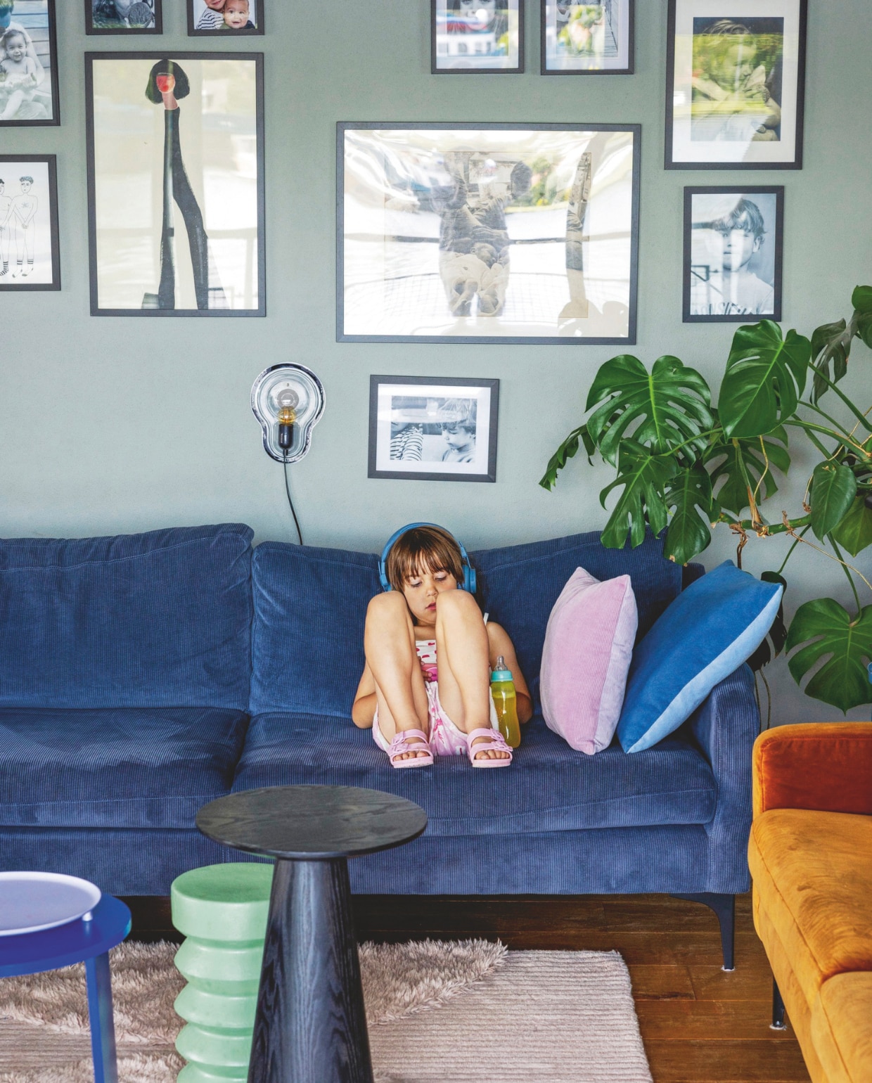Blauwe bank Sofa Company. Kussens Hema. Sticky Lamp van Droog design. Zwarte print Loods 5. Illustratie Helen B., verder familiefoto’s. vtwonen 05-2025 | styling Ilona Jongepier | fotografie Dana van Leeuwen | tekst Chris Muyres