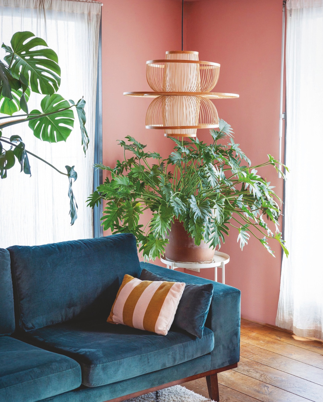 Wandkleur Faded Terracotta van Farrow & Ball. Bank Sofa Company. Gestreept kussen Hema. Plantentafel Ikea. Hanglamp Sissy-Boy. Gordijnen H&M. vtwonen 05-2025 | styling Ilona Jongepier | fotografie Dana van Leeuwen