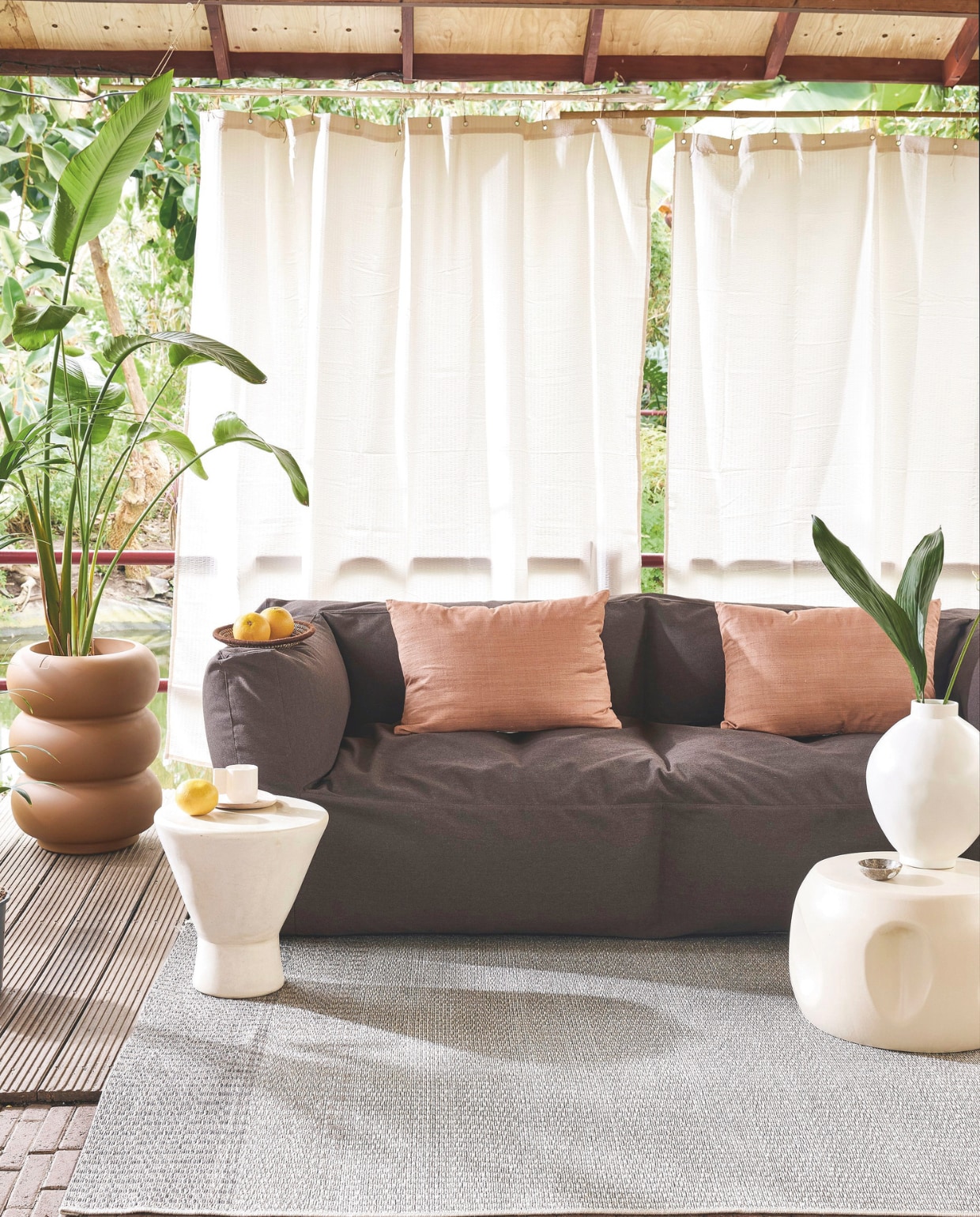 Polypropyleen buitenkleed Tide, 60x230 cm € 159,-.M.m.v. bryck.nl (bank), shop.vtwonen.nl (plantenpot Elho, kussens Urban Nature Culture, bijzettafel links en mok Household Hardware), hkliving.com (bijzettafel rechts), hm.com (douchegordijnen). Overig privébezit. vtwonen 05-2025 | styling Marlies Does | fotografie Peggy Janssen