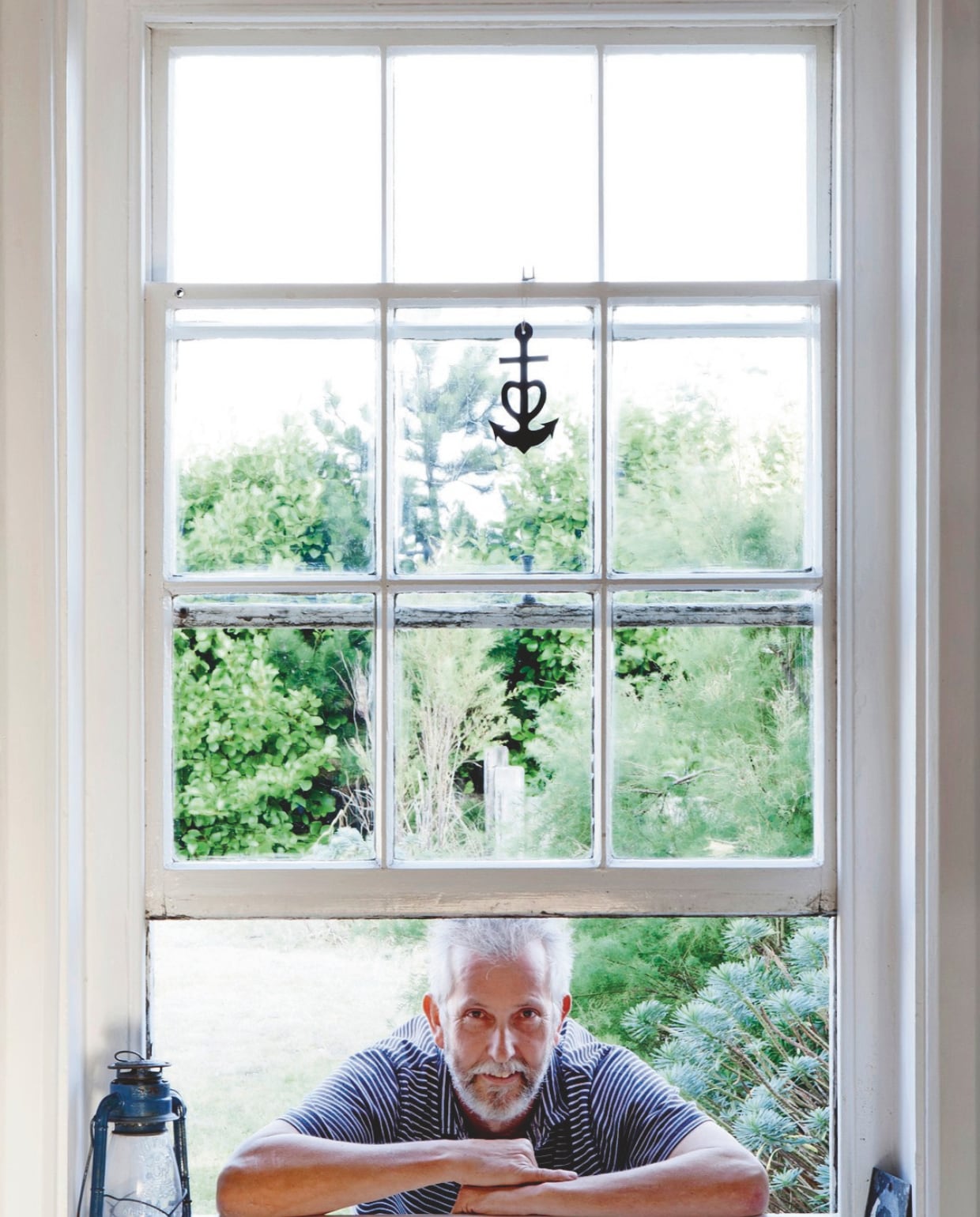 Martin vanuit de voortuin, kijkend naar de keuken. Hij werd een paar jaar geleden bemanningslid van de Walmer Lifeboat Station. vtwonen Landelijk 04-2025 | styling Miriam Hannemann | fotografie André Reuter