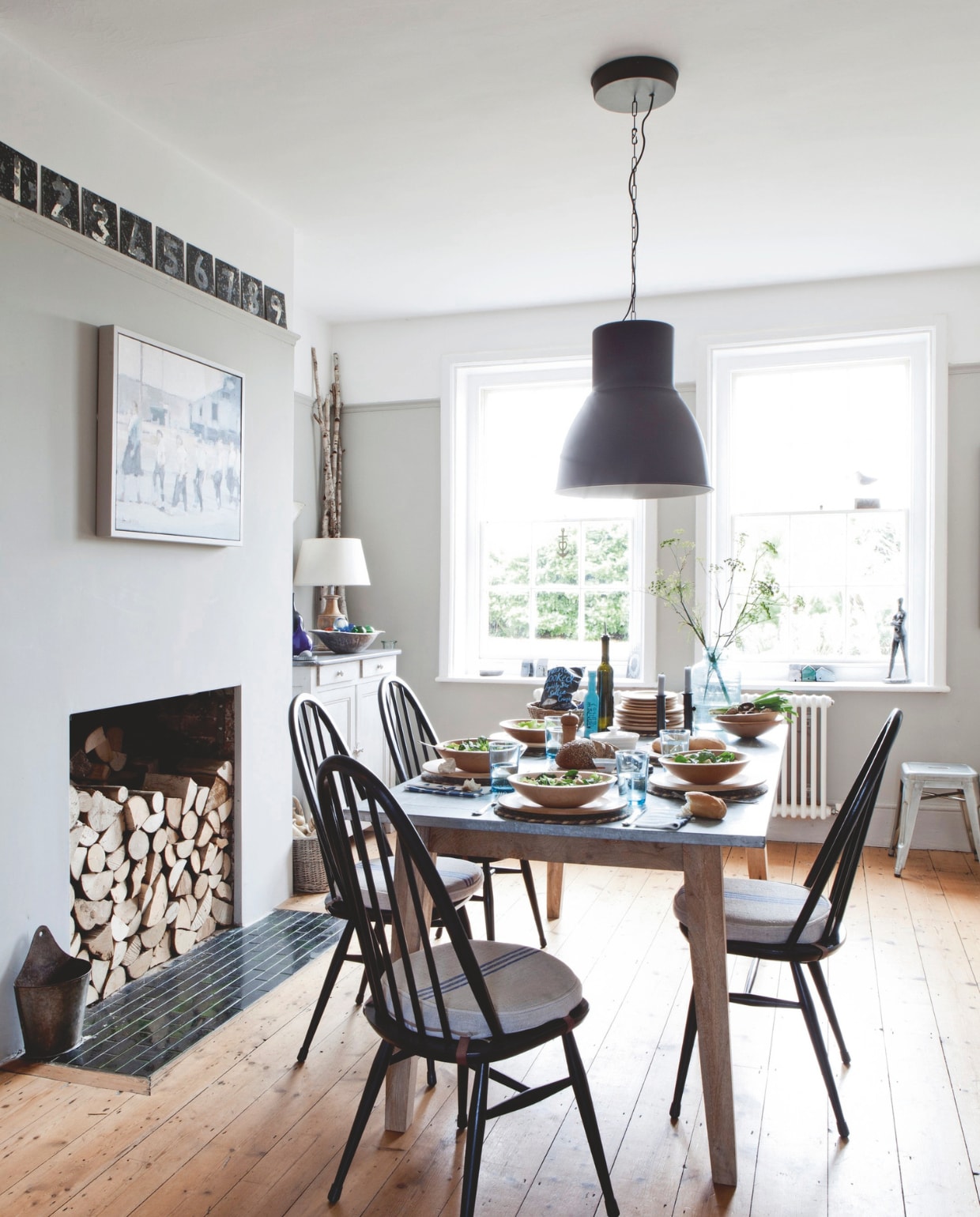 Eettafel Barker and Stonehouse. Houten ladekast en vintage eetkamerstoelen Ercol van Mileage, een antiekwarenhuis in Deal. Nummers van oud cricket-scorebord. Vergelijkbare hanglamp Hektar van Ikea. Sculptuur in het kozijn cadeau. vtwonen Landelijk 04-2025 | styling Miriam Hannemann | fotografie André Reuter