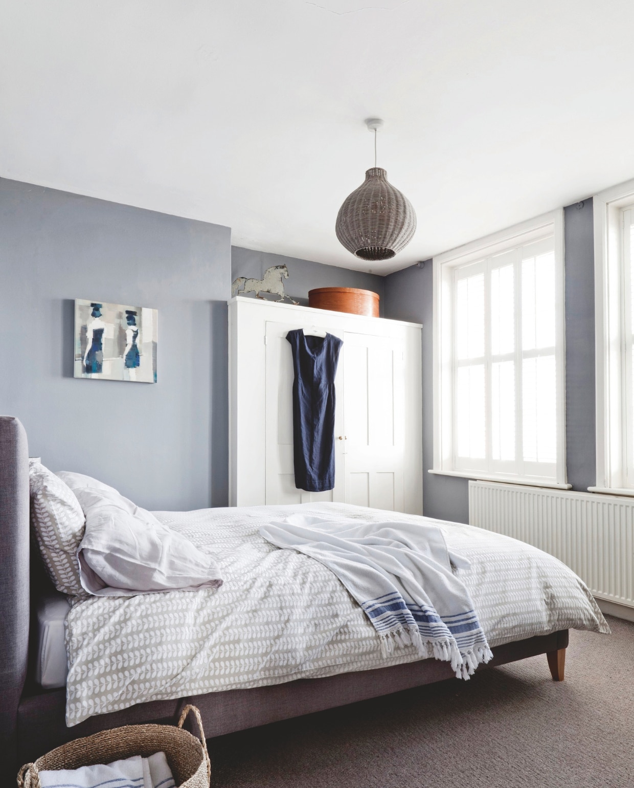Slaapkamer met kleurpalet gebaseerd op het strand. Linnenkast maatwerk. Houten opberger op de kast typische spanen Shaker-doos. Schilderij door Caroline Yates. vtwonen Landelijk 04-2025 | styling Miriam Hannemann | fotografie André Reuter