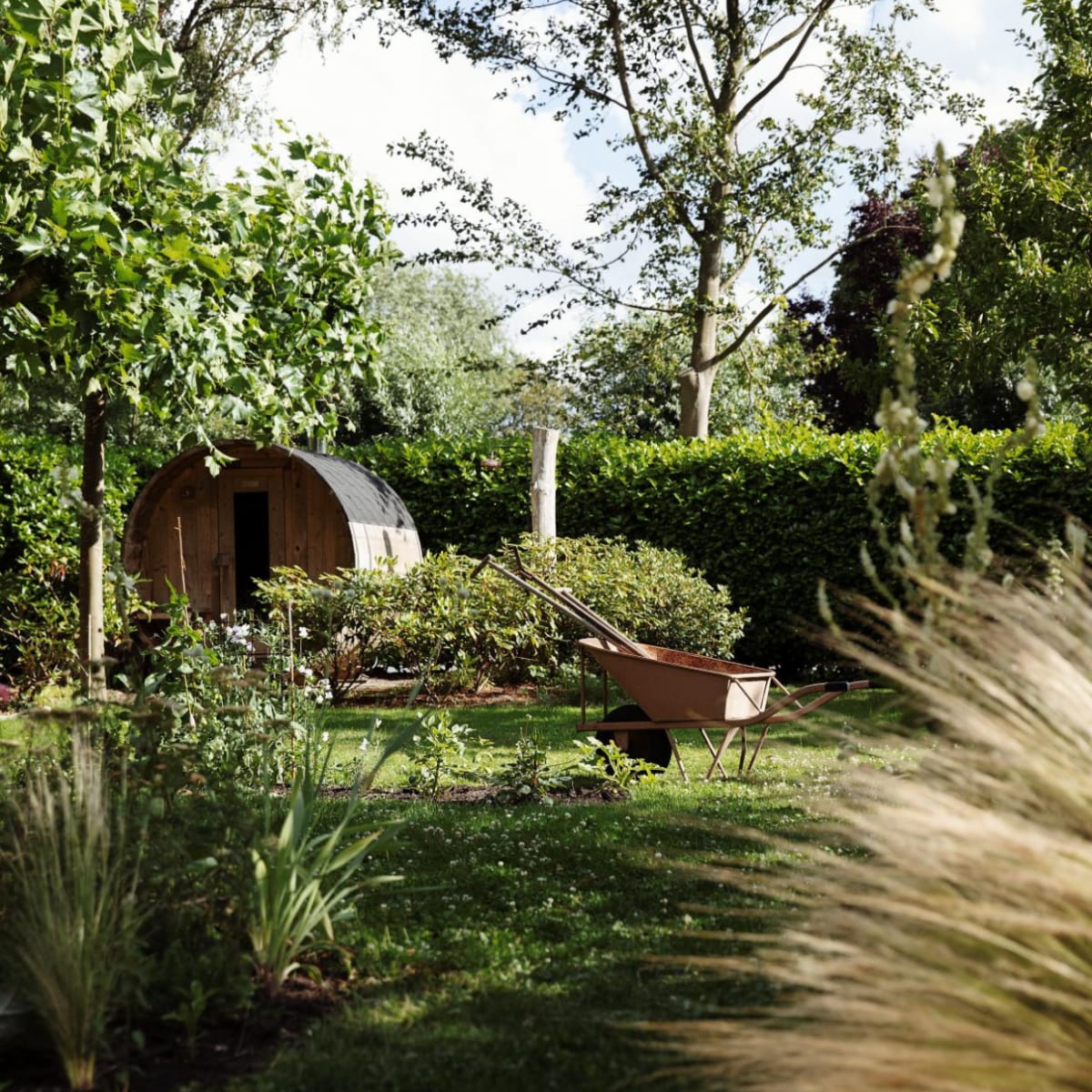 Sauna van Barrelsauna. Taxus- en laurierhagen en een wand van bamboe vormen de erfafscheiding, alles blijft groen in de winter. In de border bij de sauna staan rododendrons.

 vtwonen Tuin 09 | styling Ilona Jongepier | fotografie Dana van Leeuwen